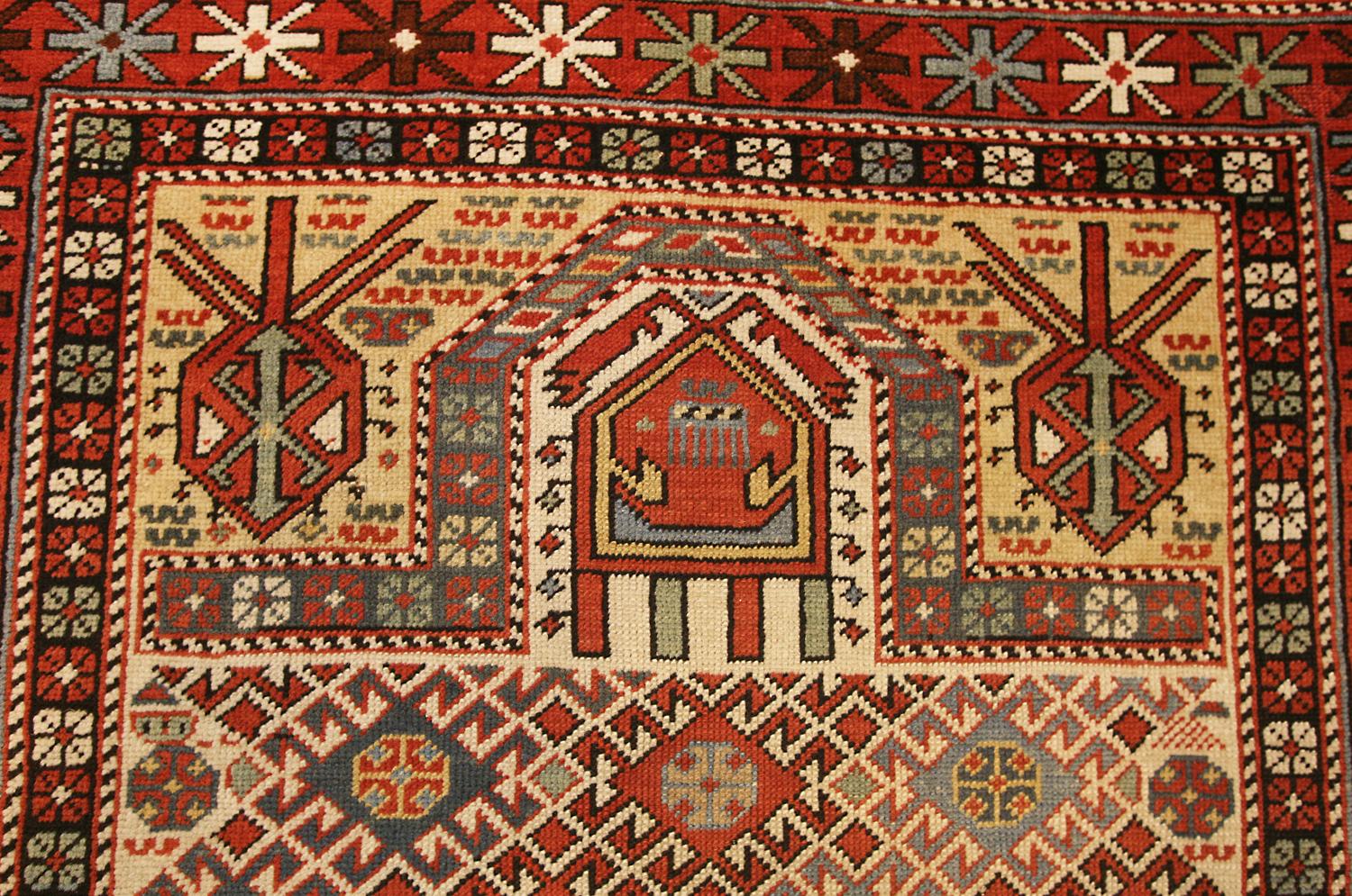 An antique Dagestan prayer rug, Caucasus The ivory field with overall multicolored hold lozenge lattice containing hooks octagonal panels. Mihrab above with stylized hooked panels and small angular bars. In the rust-red border of polychrome panels