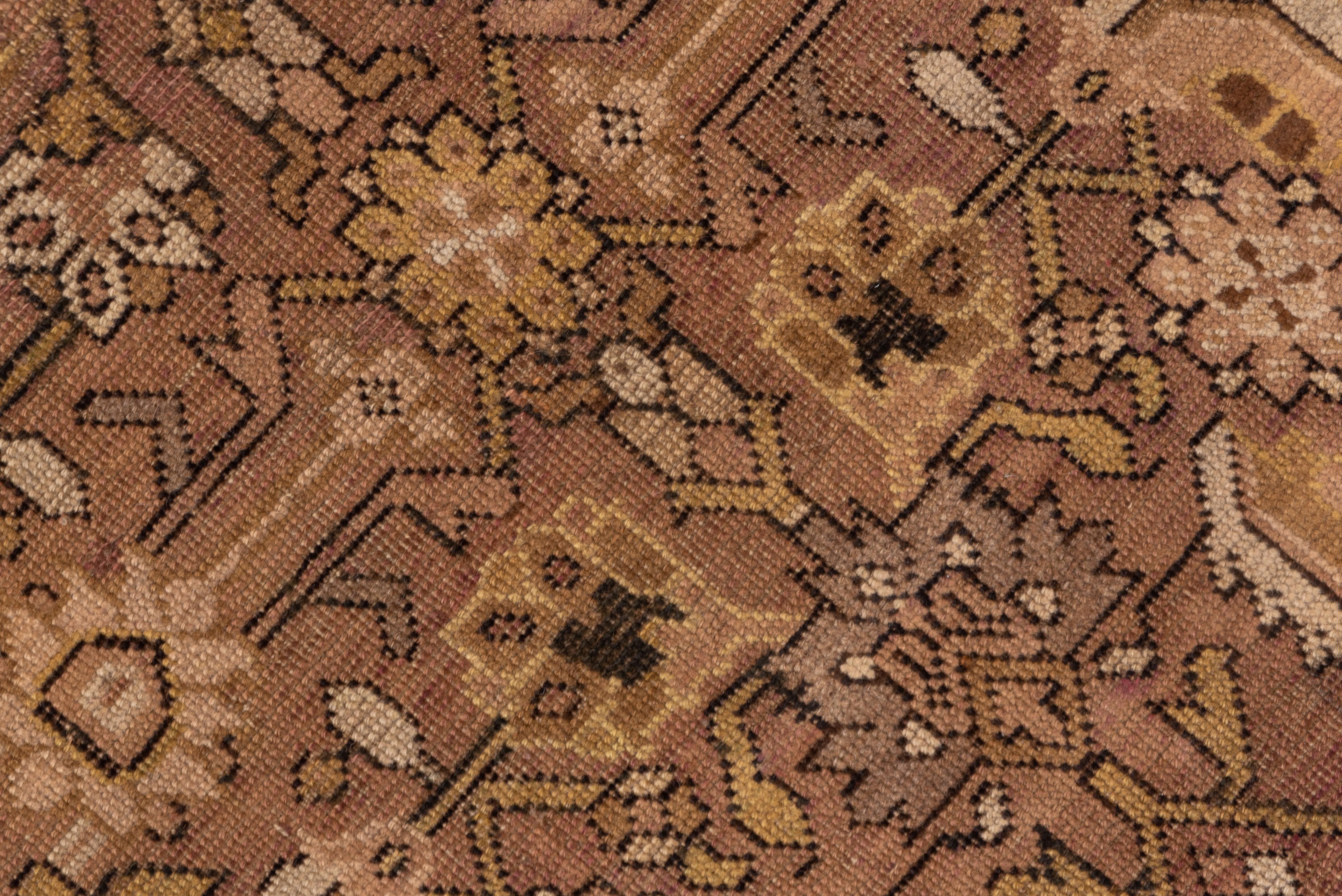 In a Persian style, this South Caucasian kellegi (long carpet) shows a Herati design with fat leaves dominating small rosettes, all on the light brown ground. Sienna brown main border with reversing, flattened reversing fan palmettes. Wool