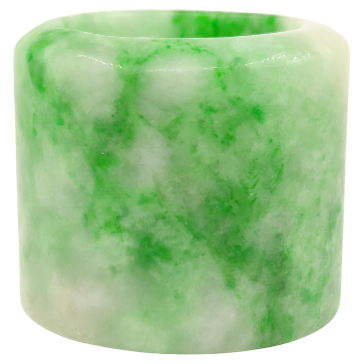 Fine antique Chinese hand carved jadeite archer's thumb ring with natural mottled emerald green color inclusions on white ground, the natural jadeite material is translucent and untreated.

This is a very fine example of Chinese jadeite thumb rings