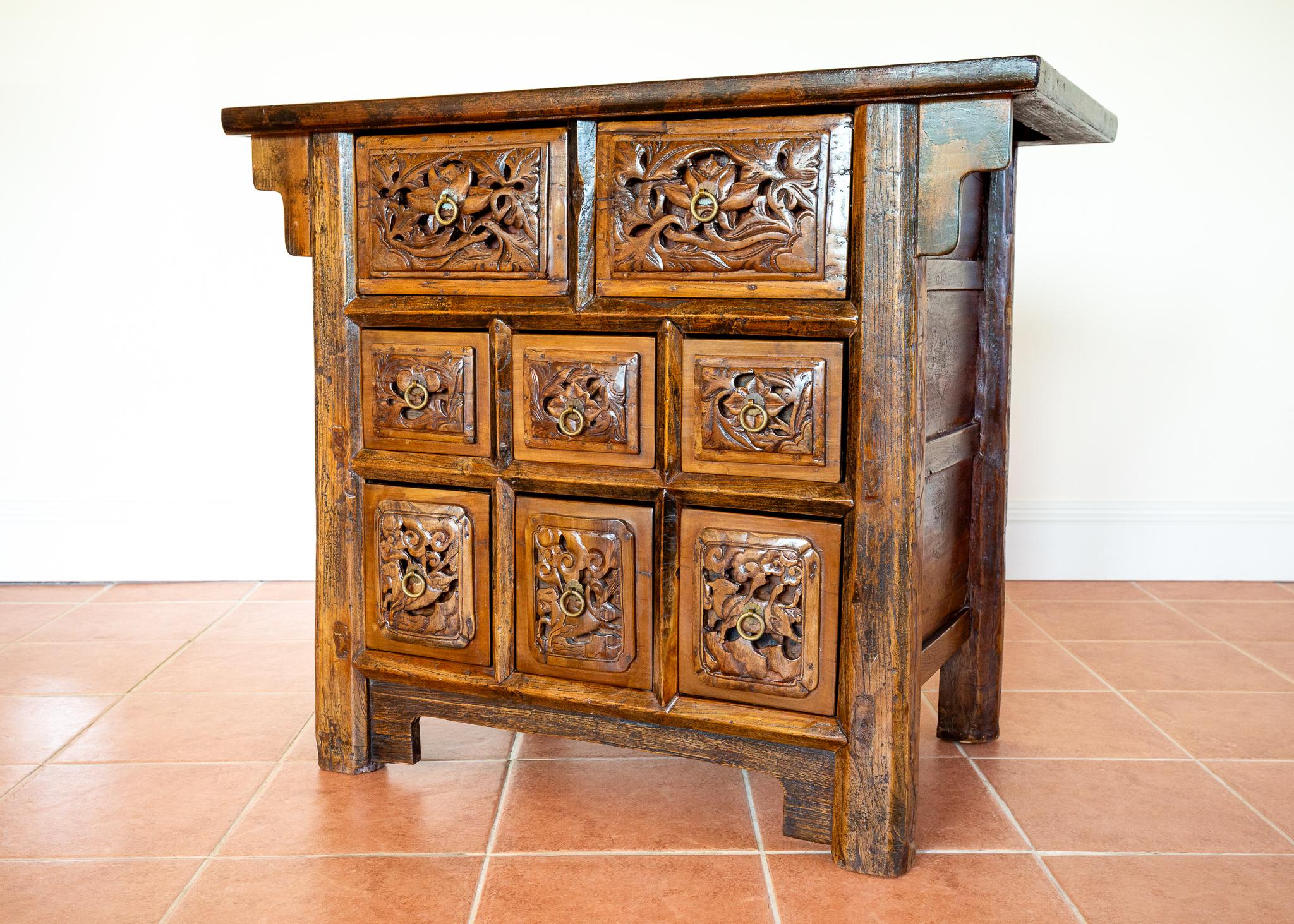 Una excepcional, impresionante y rarísima cómoda china tallada, en magnífico estado antiguo. Fabricado probablemente en el norte de China a finales del siglo XVIII o principios del XIX, este mueble de ocho cajones, magníficamente decorativo y