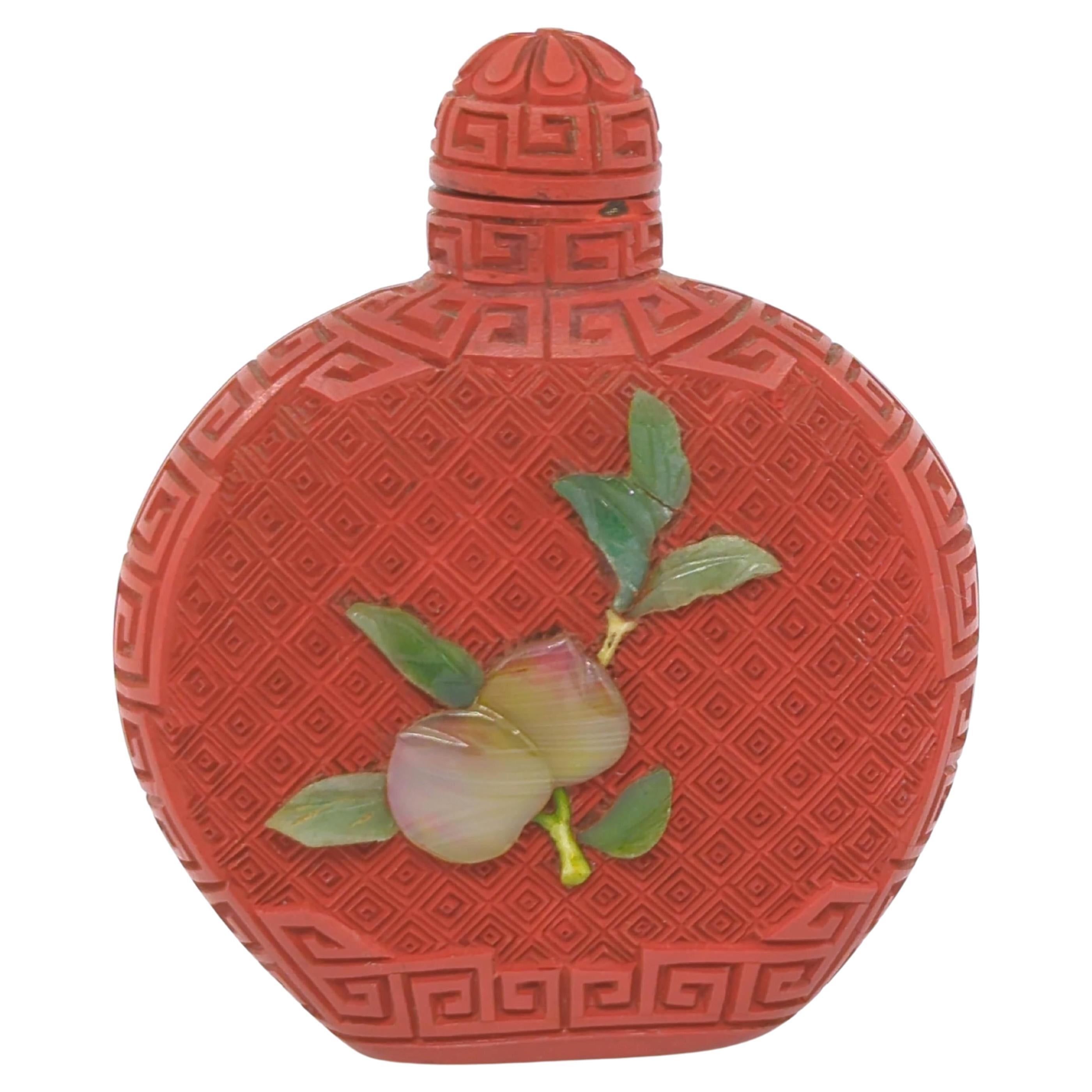 Diese Zinnober-Schnupftabakflasche aus der Zeit der Republik China ist eine meisterhafte Mischung aus komplizierter Handwerkskunst und symbolischer Kunstfertigkeit. Die abgeflachte, kugelförmige Flasche dient als Leinwand für eine sorgfältig