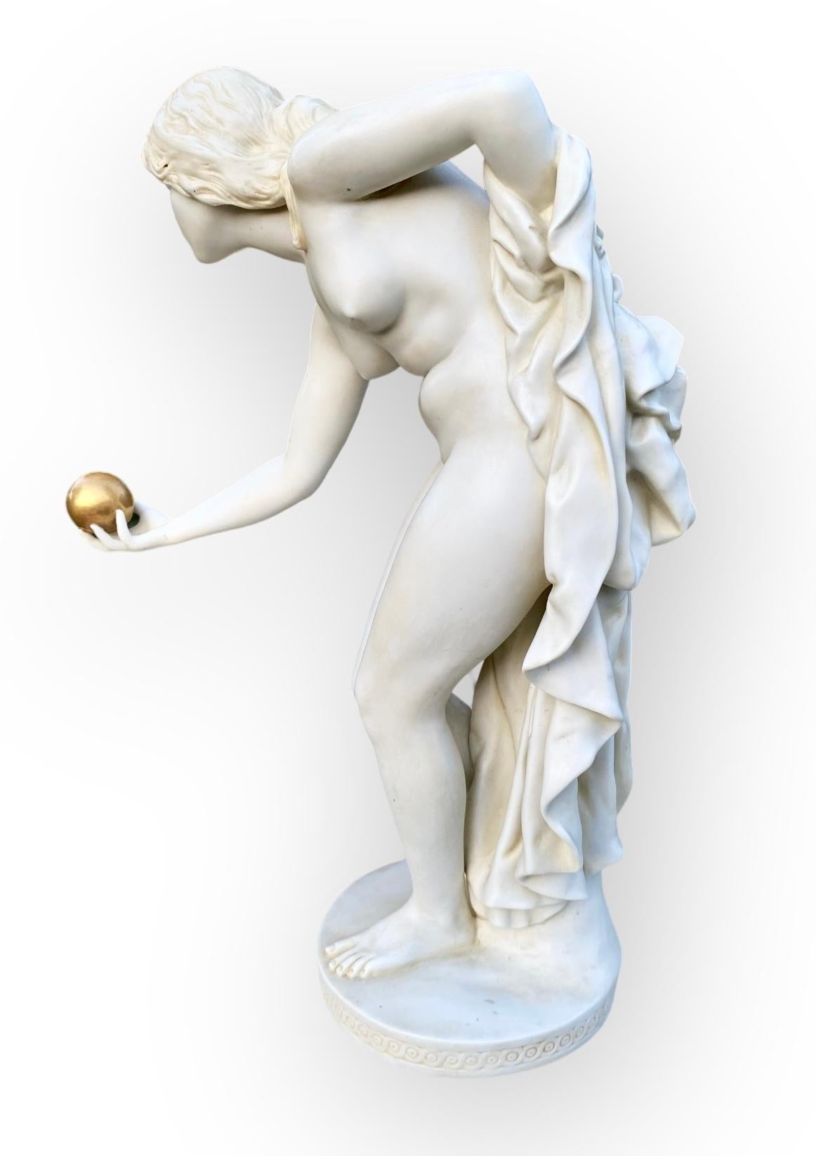 Bella figura parigina antica dell'inizio del XX secolo di una donna bionda nuda che tiene una palla dorata nella mano destra. L'attenzione per i dettagli si nota nelle dita, nei piedi e nel viso delicatamente resi. 
Il pario è una fine porcellana