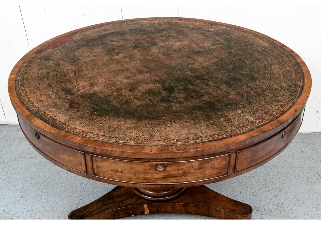 Classic Antique Bankers Table with embossed mottled brown leather top, handsome Mahogany wood with a bold turned support surmounting a Tripod base with flat bun feet. With four real drawers and four false front drawers, the drawers in hardwood with