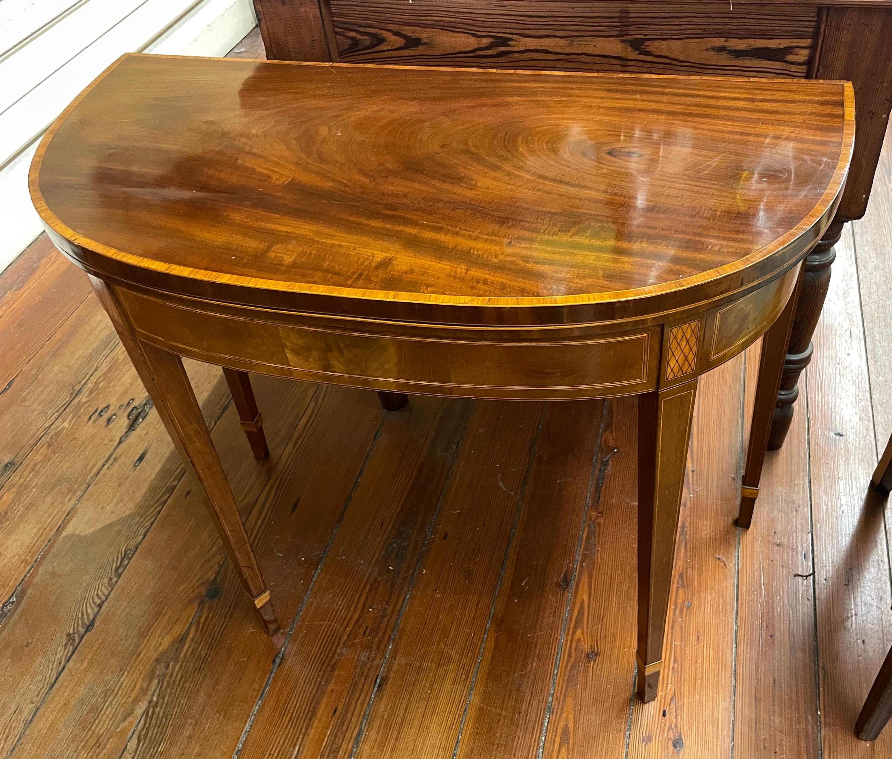 This is a marvelous Antique English Geo. III inlaid figured mahogany Hepplewhite style flap-top Games Table or Console with a superbly inlaid apron; gate-leg and finely figured mahogany interior.  It may be used open as a games table or small