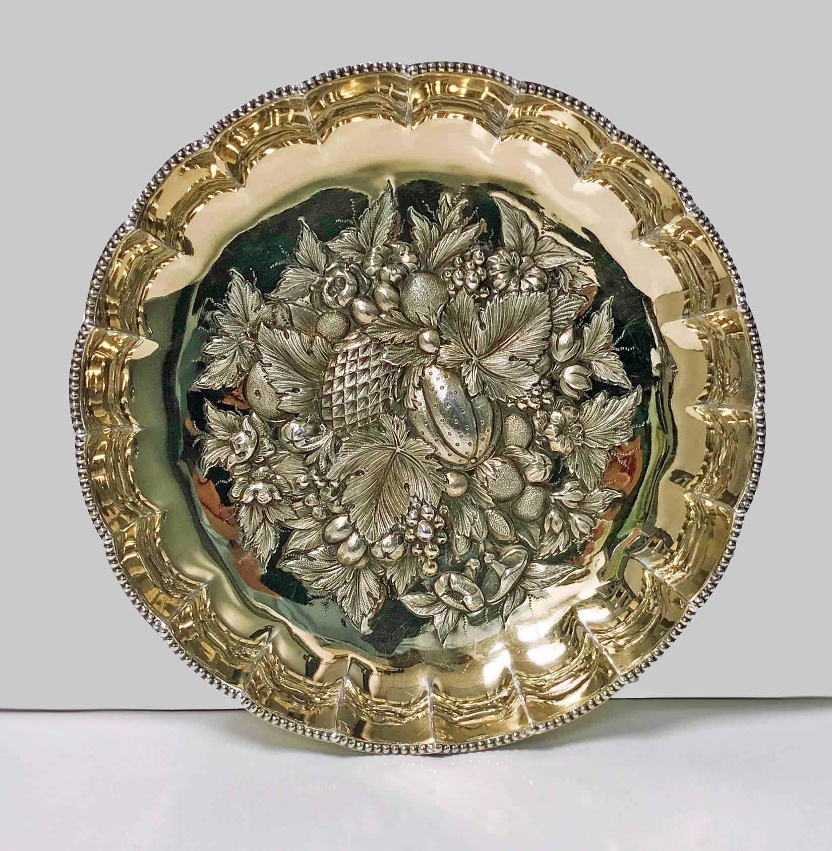 Fine antique English silver gilt fruit bowl, 1911 James Dixon & Sons. The circular bowl on bead border base rising to scalloped lobate surround, the centre with very elaborately embossed repousee fruits and foliage decoration. Original gilding.