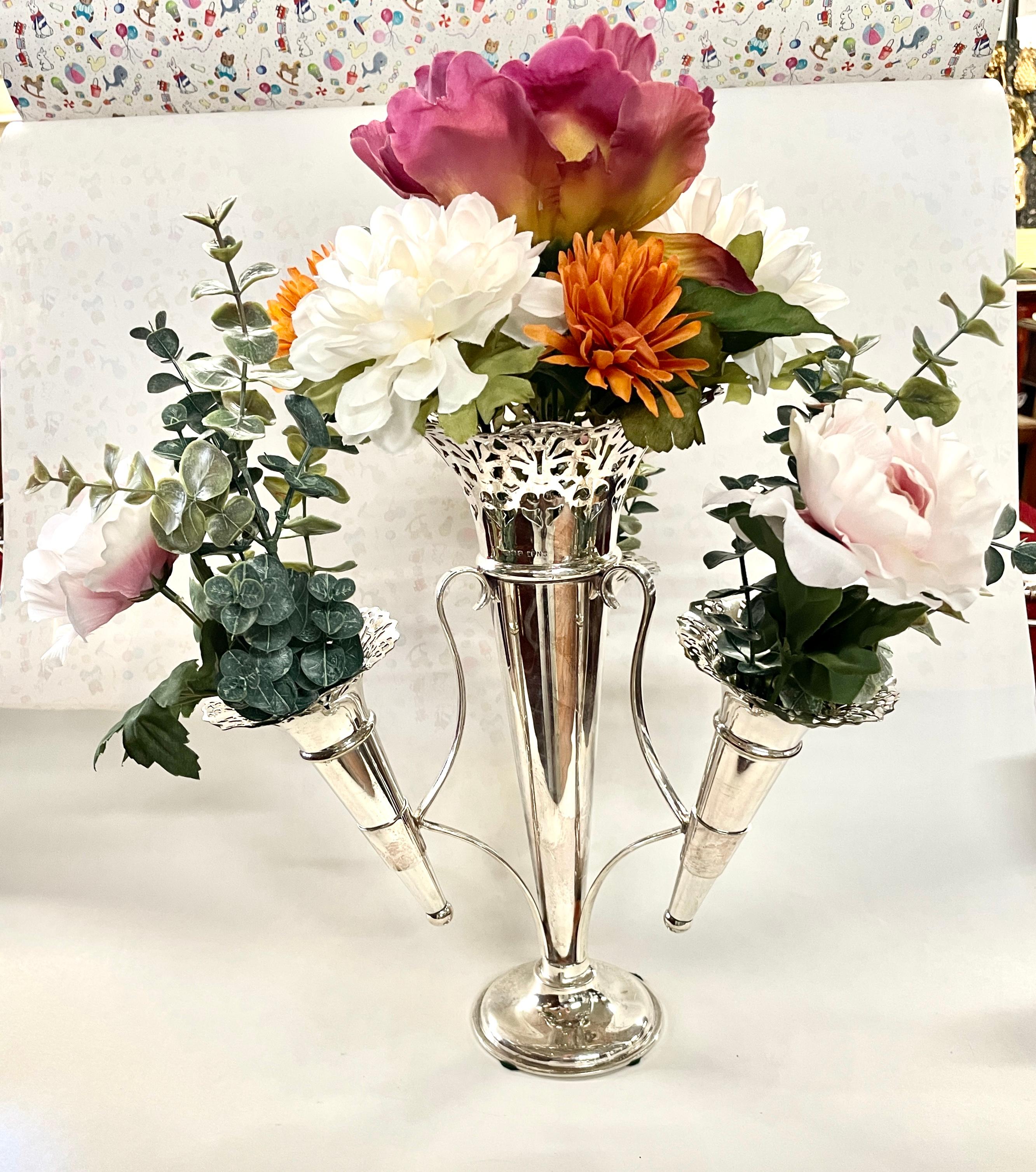 This gorgeous Antique English silver plated four-tube Floral Epergne (Centerpiece) is in pristine condition with no plate loss whatsoever.  The flange of each trumpet-shaped tube is delicately hand pierced.  There are maker's marks on the base for