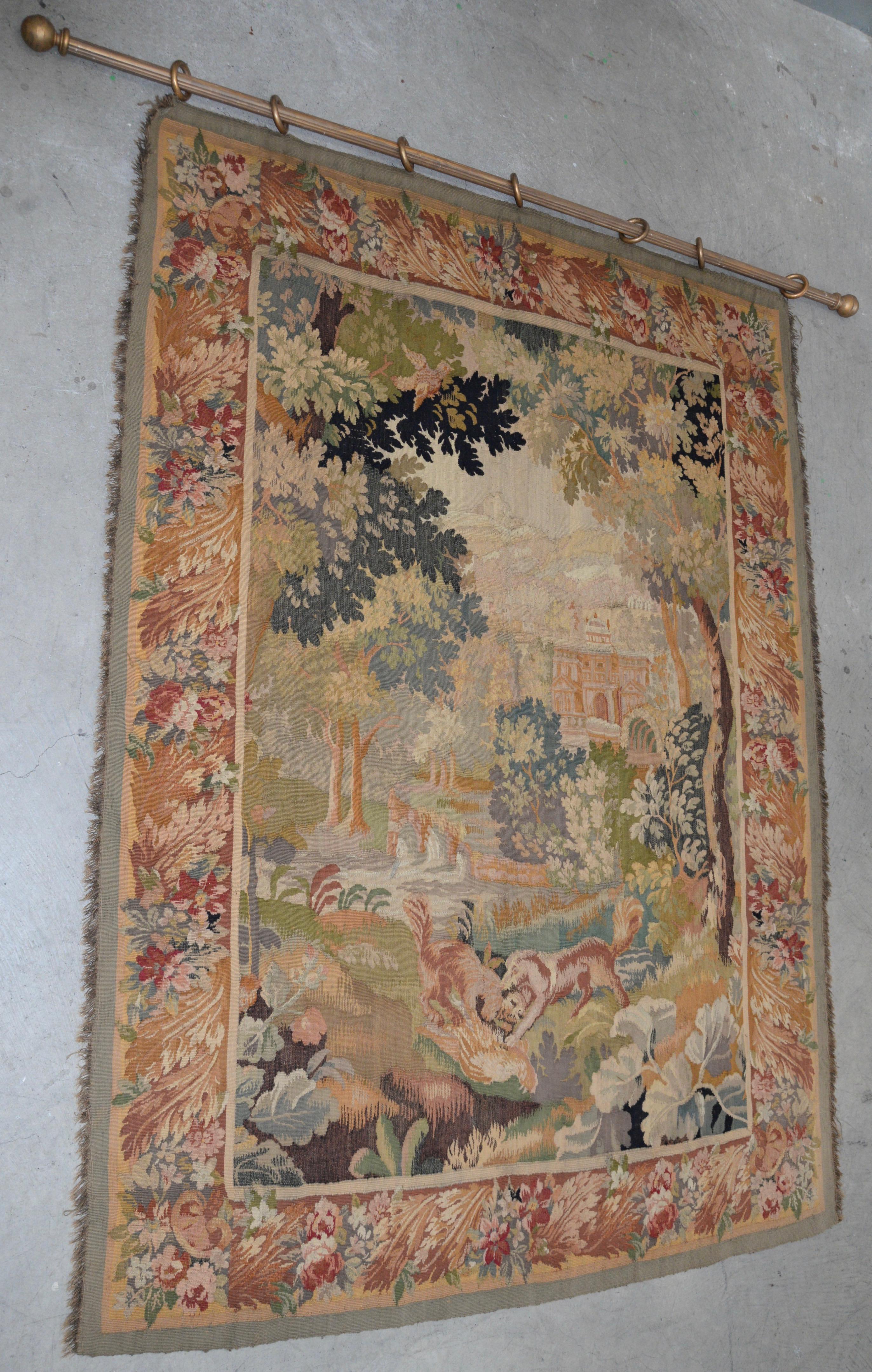 Fine antique European Tapestry depicting a country scene with dogs

This is a large 19th century tapestry. The background of the tapestry shows a mountain village with a large palace and smaller homes on the hillsides. The foreground of the