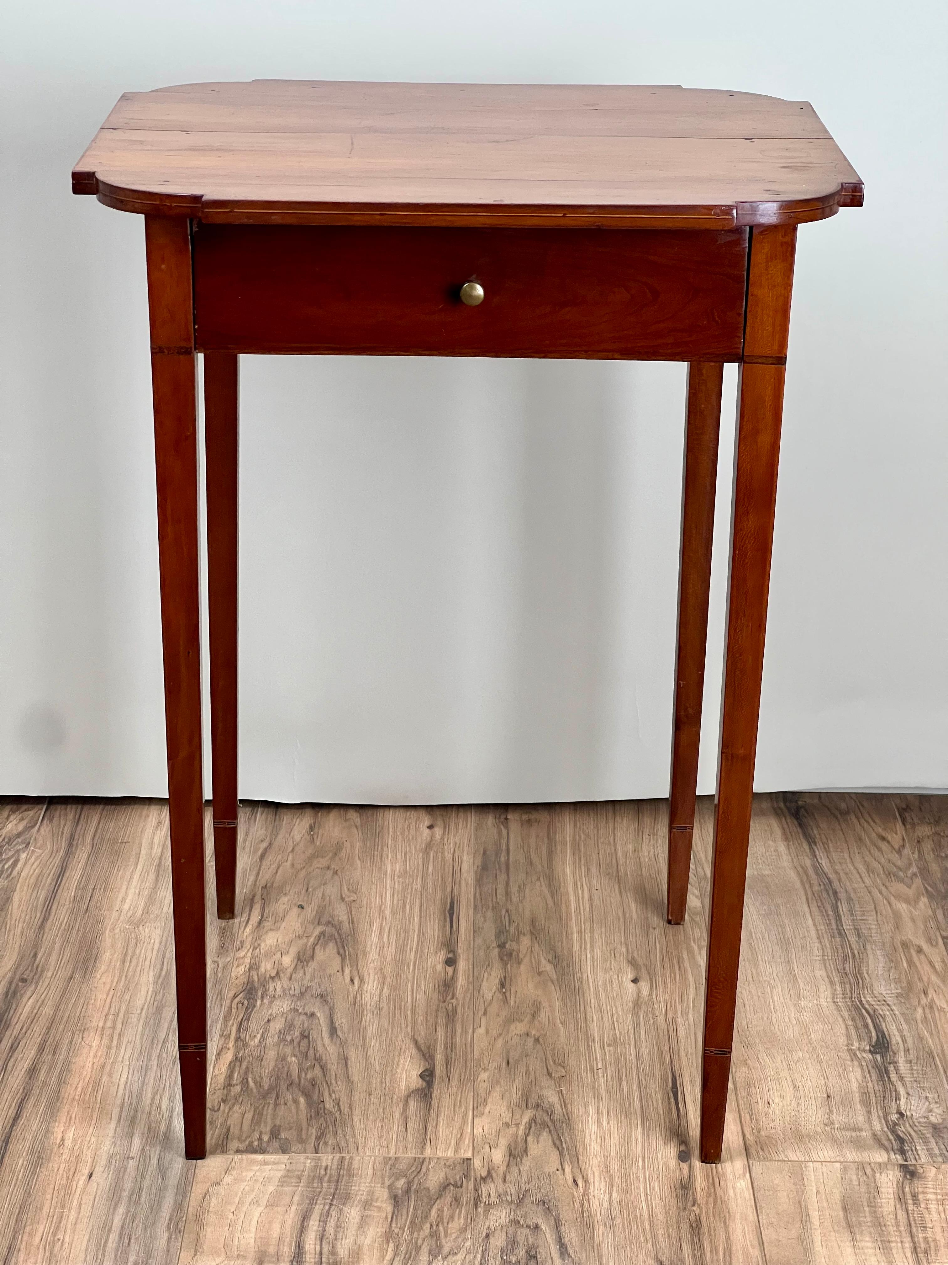 This fine Federal period cherry stand, dating to around 1820, embodies the elegant simplicity and refined craftsmanship of early 19th-century American furniture. The stand features classic Hepplewhite lines with delicate tapering legs and a single