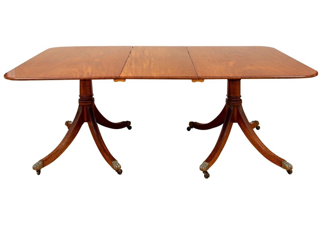A full antique double pedestal table in a refined more modest size not requiring a very large space. The fine quality dining table with drop-ends supported by pedestals, along with a center leaf. The pedestals with cylindrical supports with ring