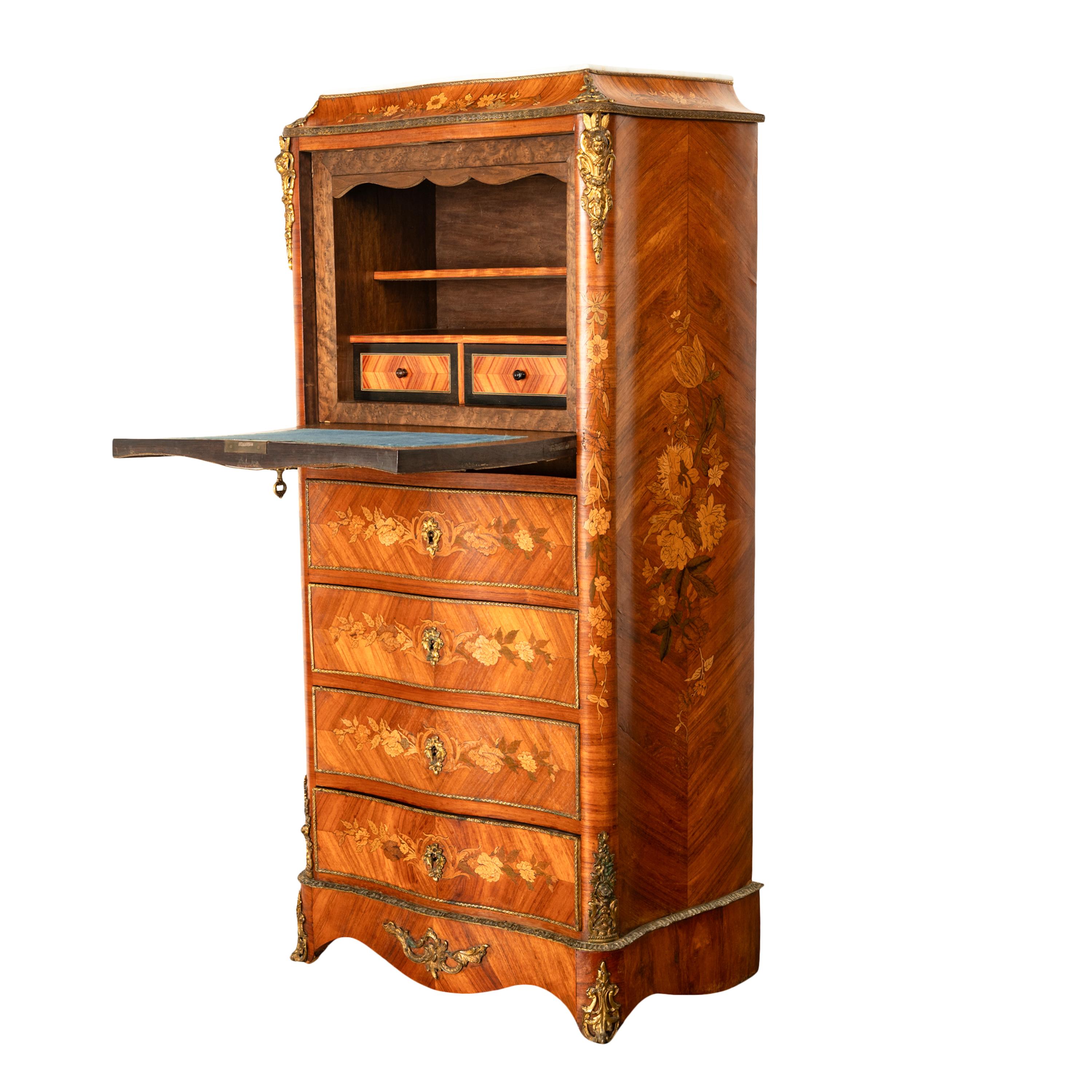 A very fine quality antique French Louis XV rosewood, marquetry, ormolu and marble topped secretaire abattant, circa 1880.
The serpentine shaped secretary is modeled as a semainier ( seven drawer chest), the feather-banded rosewood case is