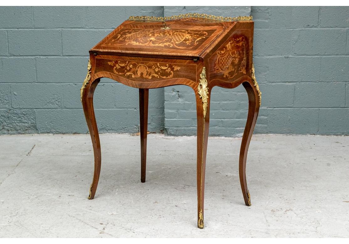 Très beau bureau de dame de style Louis XV. Bureau de dame ancien, avec une marqueterie très détaillée en bois exotique et des montures en bronze. Le bureau avec une légère forme de bombe s'ouvre pour révéler un compartiment horizontal ouvert
