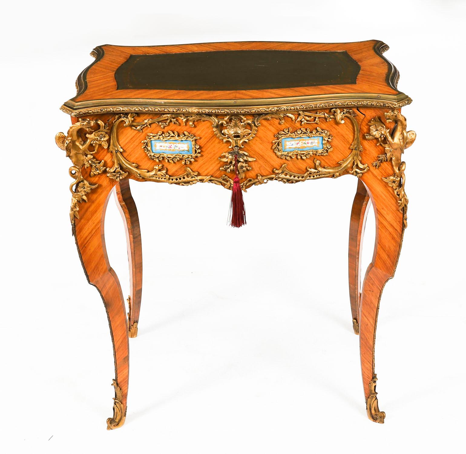 Un beau bureau plat français ancien en bois, porcelaine et bronze doré, à la manière de Linke, datant d'environ 1860.
 
Le plateau serpentin monté en bronze doré est équipé d'une surface d'écriture en cuir vert doré, au-dessus d'une frise ondulée