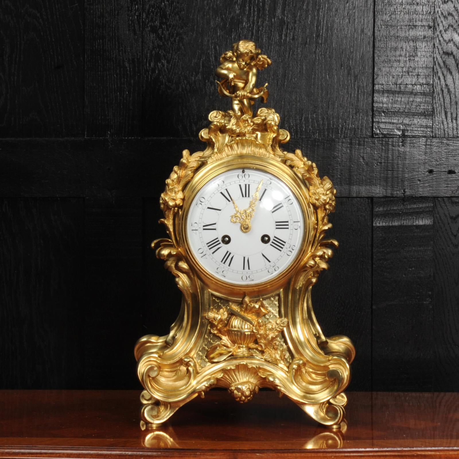 Une très belle et substantielle horloge en bronze doré de l'horloger Vincenti. Superbe forme de ballon rococo composée d'acanthes, de volutes et d'ornements floraux. Au sommet d'une figure magnifiquement modelée de cupidon, tirant en arrière sur son
