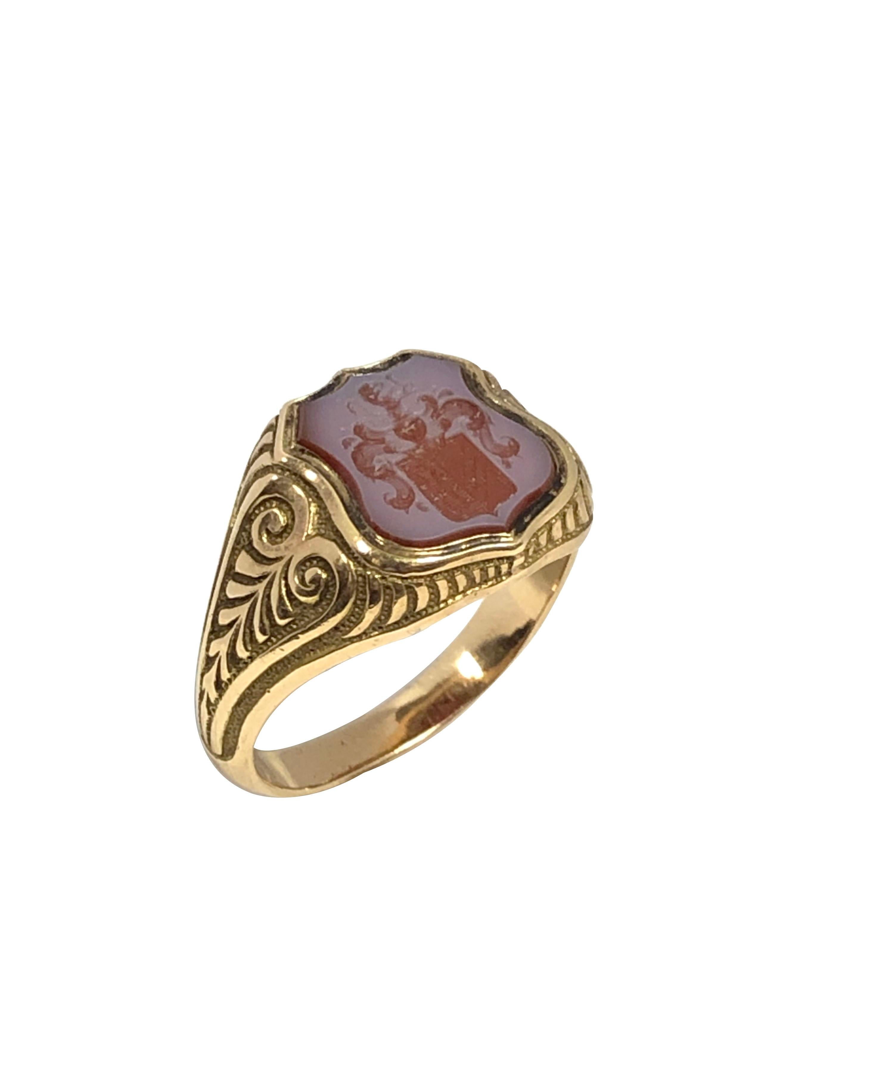Circa 1890s 14K Yellow Gold Signet Ring, Having a Shield Shape deep carved Hard Stone Agate with a Shield Crest, Hand chased Gold work on the sides. finger size 8 1/2. 