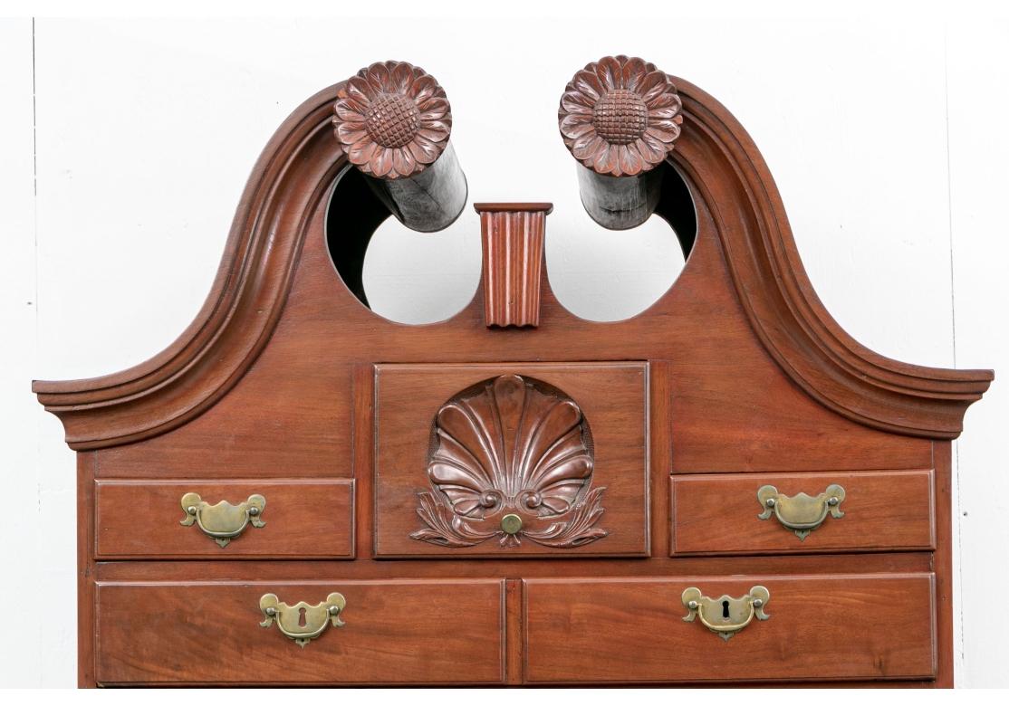 A large and very well made 19th Century American Highboy. The Chest, with fine traditional form and dove-tail construction drawers has an upper unit with strongly formed Broken Pediment with SunFlower carved accents, central Acorn form finial,