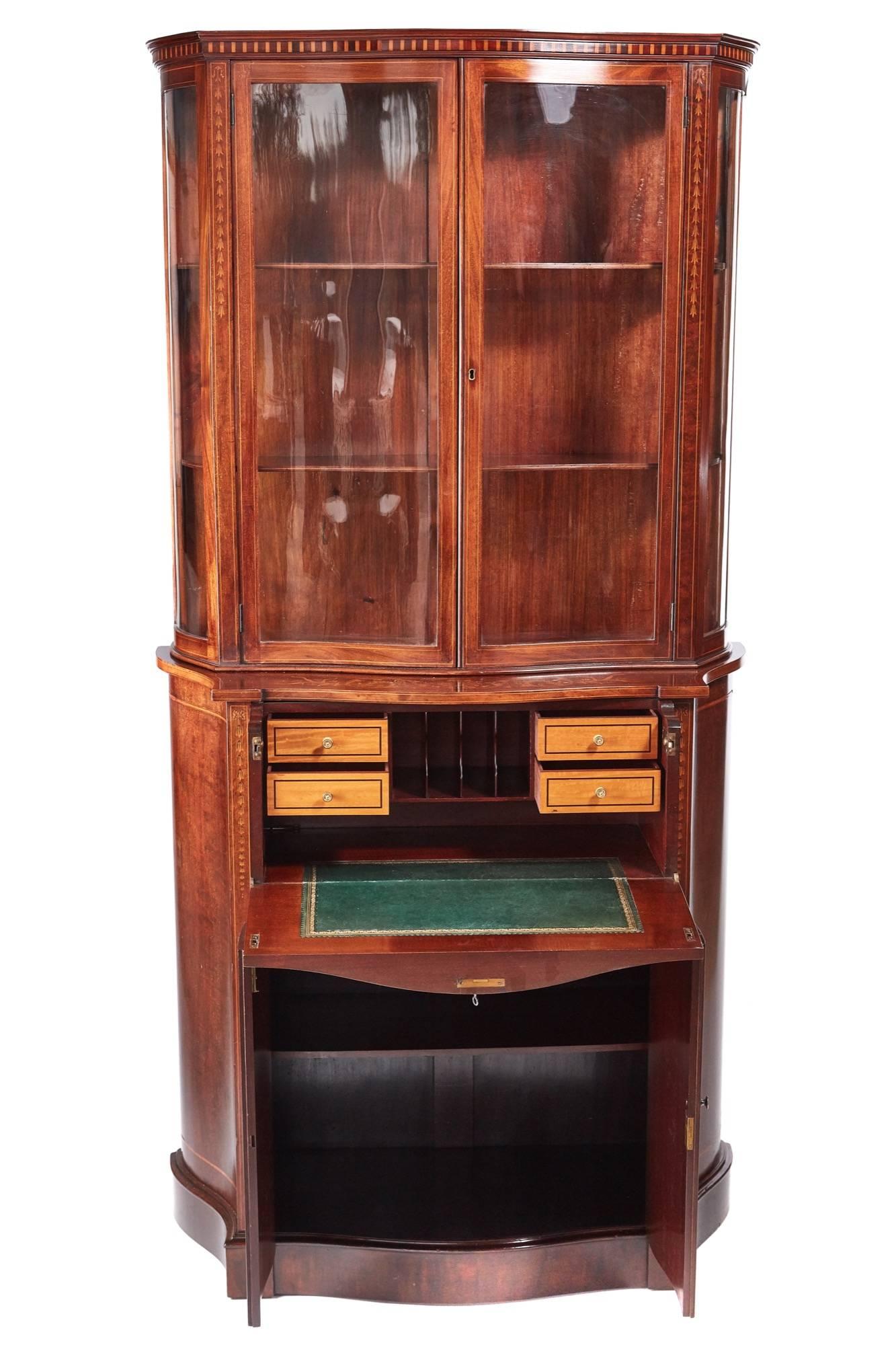 Fine quality antique mahogany inlaid serpentine shaped secretaire bookcase or cabinet, the upper section with a shaped inlaid cornice, lovely serpentine shaped glazed doors and sides, opening to reveal two adjustable shelves, the base having a fine