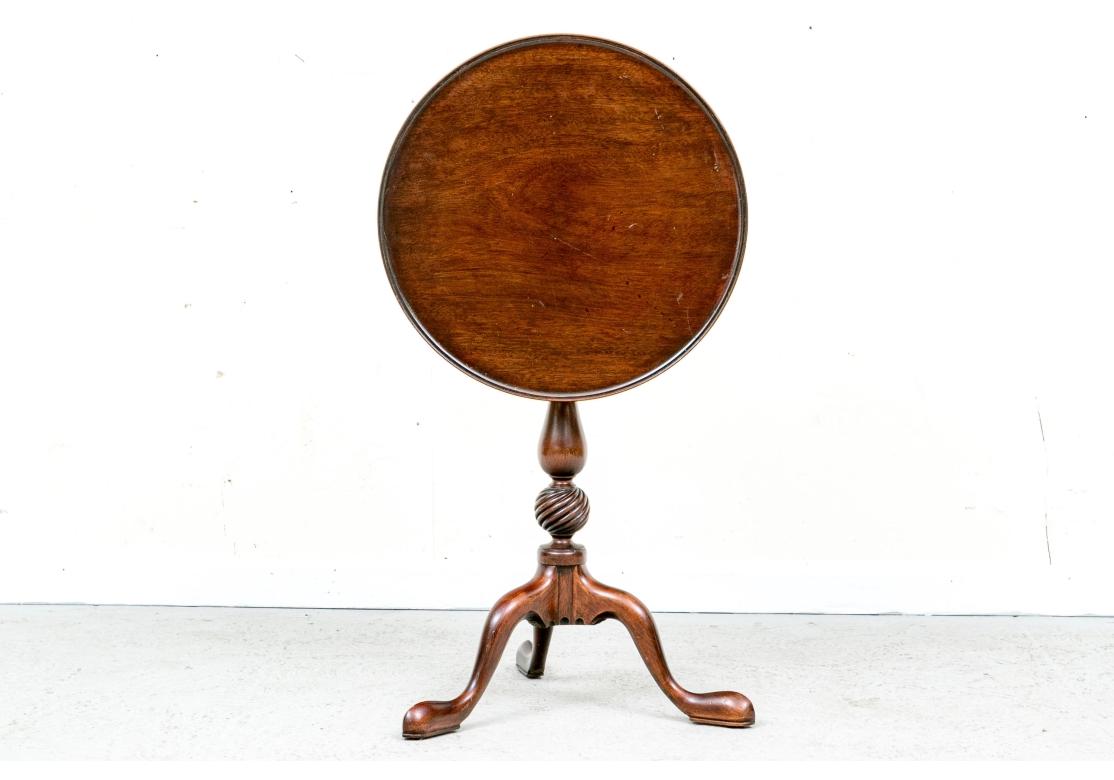 Very well made and finished Tripod Table with fine graining, turned support with decorative spiral globe accent and traditional pad foot. Brass locking catch. 

Dimensions: 19.25” diameter by 26.25” high. 

Condition: Please see detail photos. There