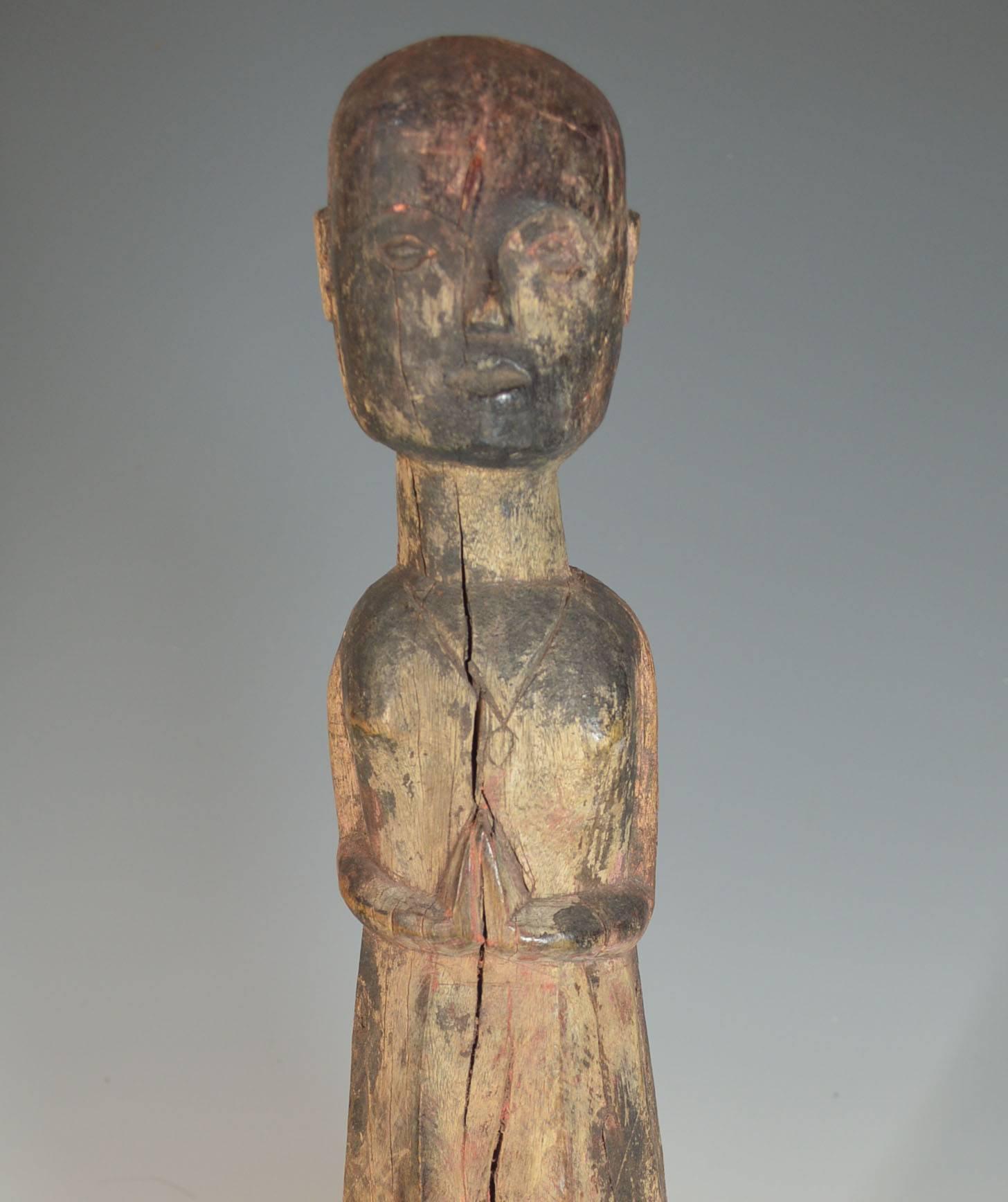 A old ancestor figure from the Tharu people of Southern Nepal.
The standing guardian figure, the face with serene enigmatic expression, the hands held in front in Namaste salutation.
Ancient weathered patina with remains of pigments, old age