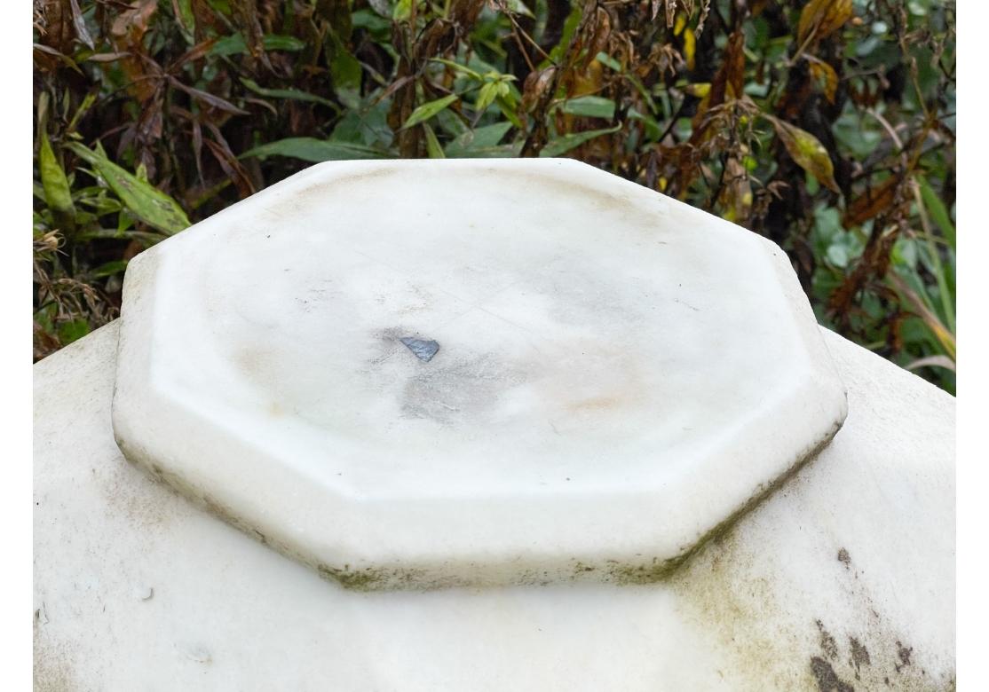 A large four section carved Marble Garden Pedestal with Octagonal cut supports surmounting a square angled base and topped by a multi-level top piece. With great weight and solidity, the Pedestal has enhancing signs of age including a few time