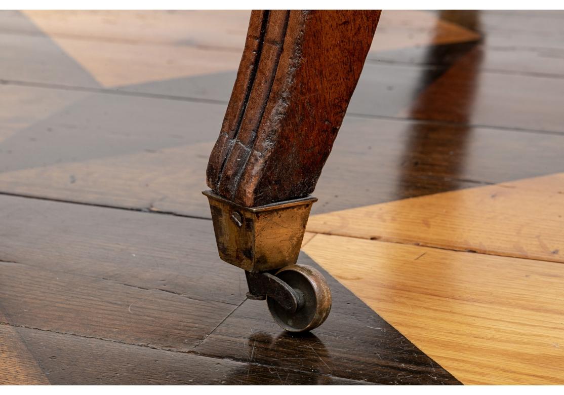 Antica poltrona in stile Regency con schienale a doghe verticali e lamelle, braccioli con manchette ben imbottite che vanno da sotto il bracciolo alla gamba. La sedia con cuscino di seduta e cuscino di schienale rimovibili ha una struttura a nastri,