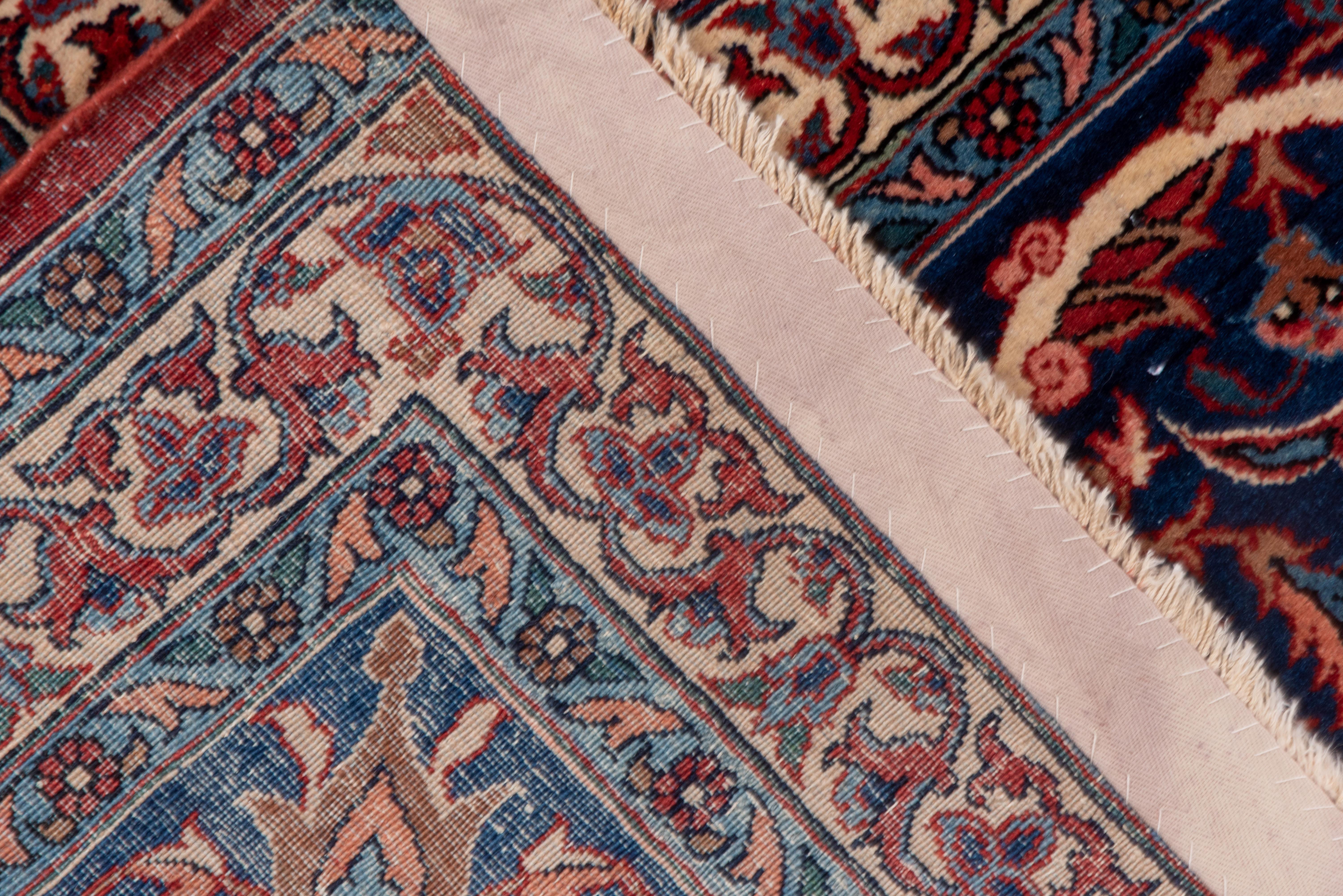 Die dunkelblaue Palmette und die dicke Arabeskenbordüre umrahmen ikonisch das rubinrote Feld mit einem hohen, leicht gewellten elliptischen Medaillon, das ein elfenbeinfarbenes florales Submedaillon einschließt. Die Ecken sind gut ausgeprägt und in