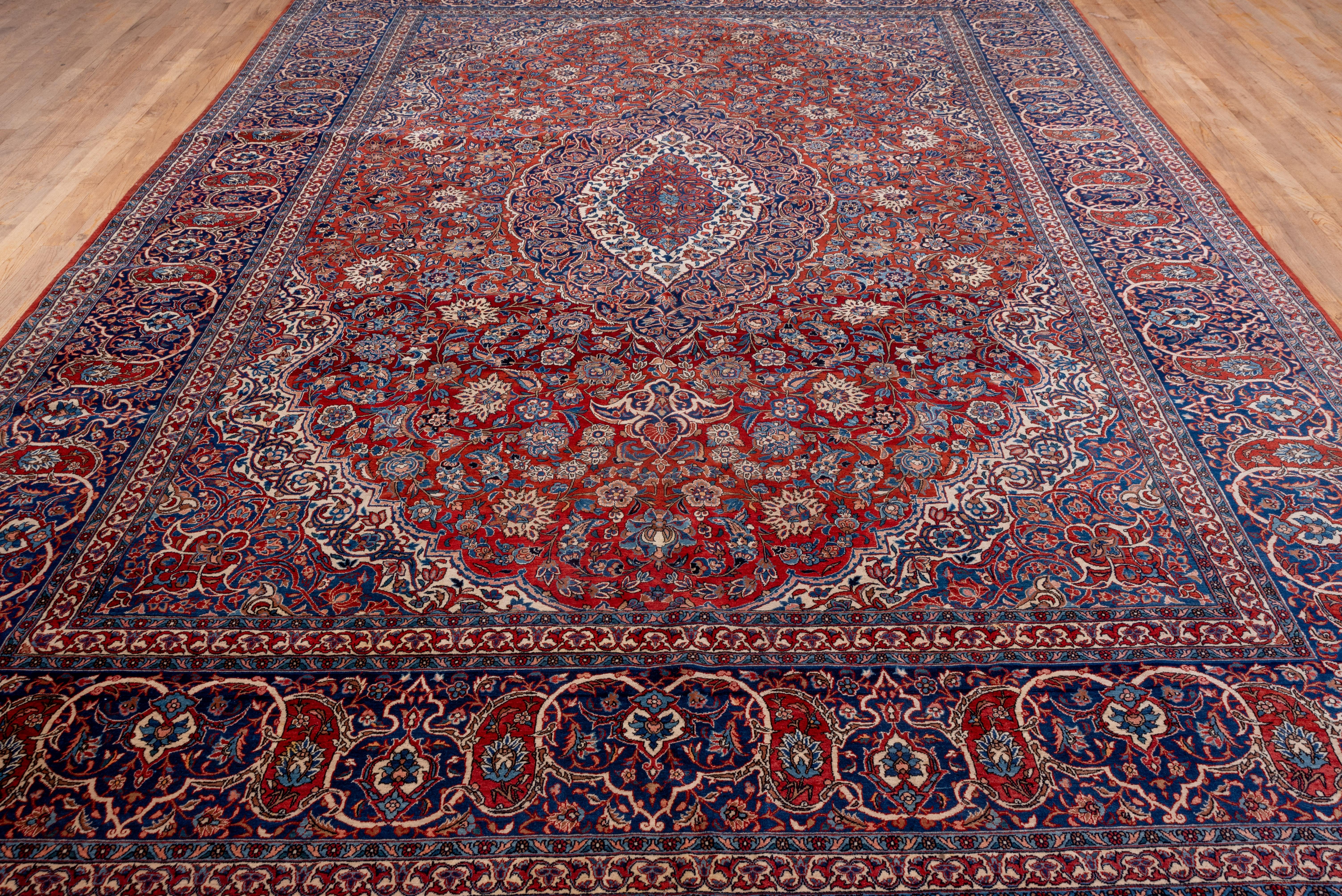 Antiker persischer Isfahan-Teppich aus Persien, rotes Feld, Medaillon in der Mitte, blaue Akzente (Handgeknüpft) im Angebot