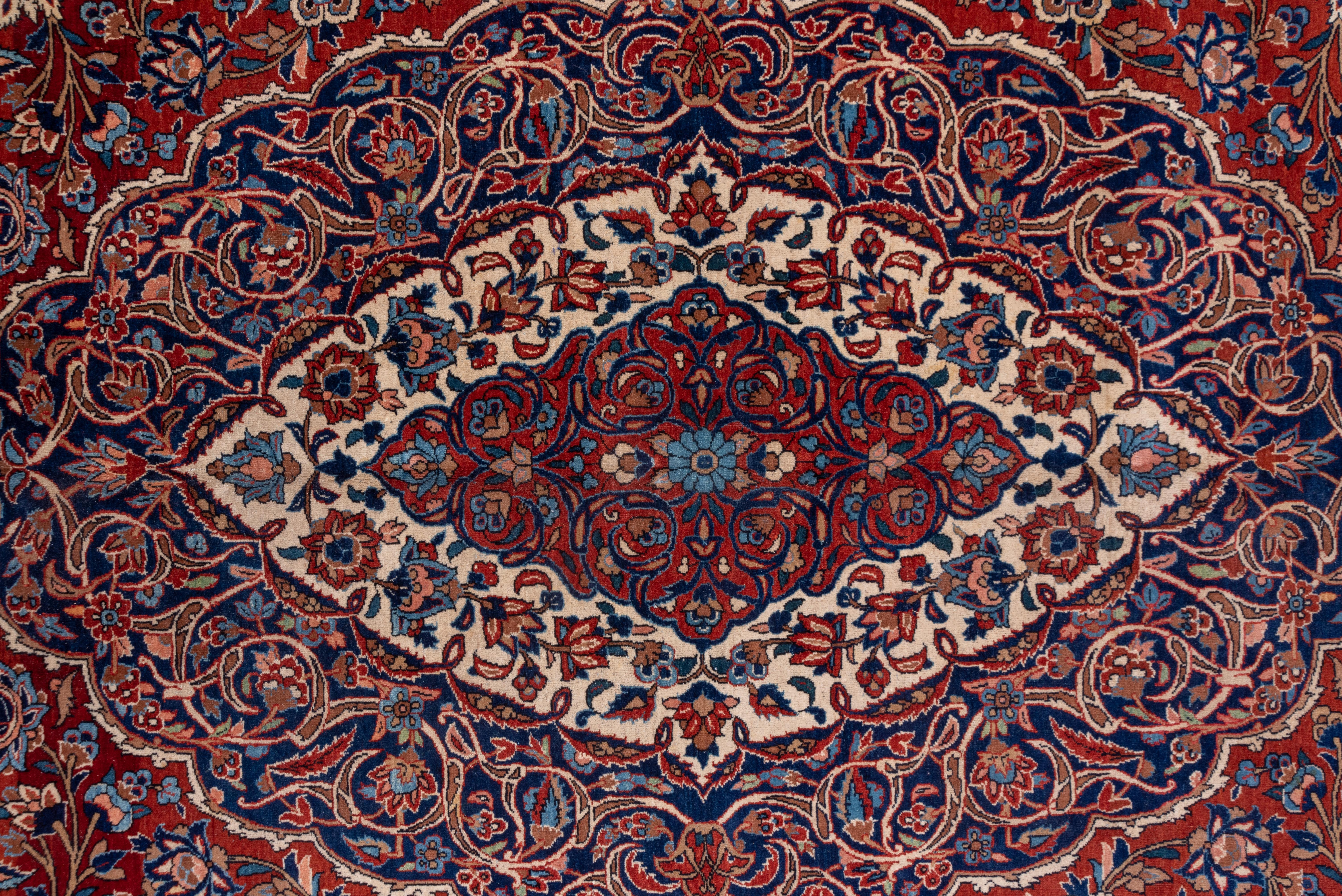 Antiker persischer Isfahan-Teppich aus Persien, rotes Feld, Medaillon in der Mitte, blaue Akzente im Zustand „Gut“ im Angebot in New York, NY