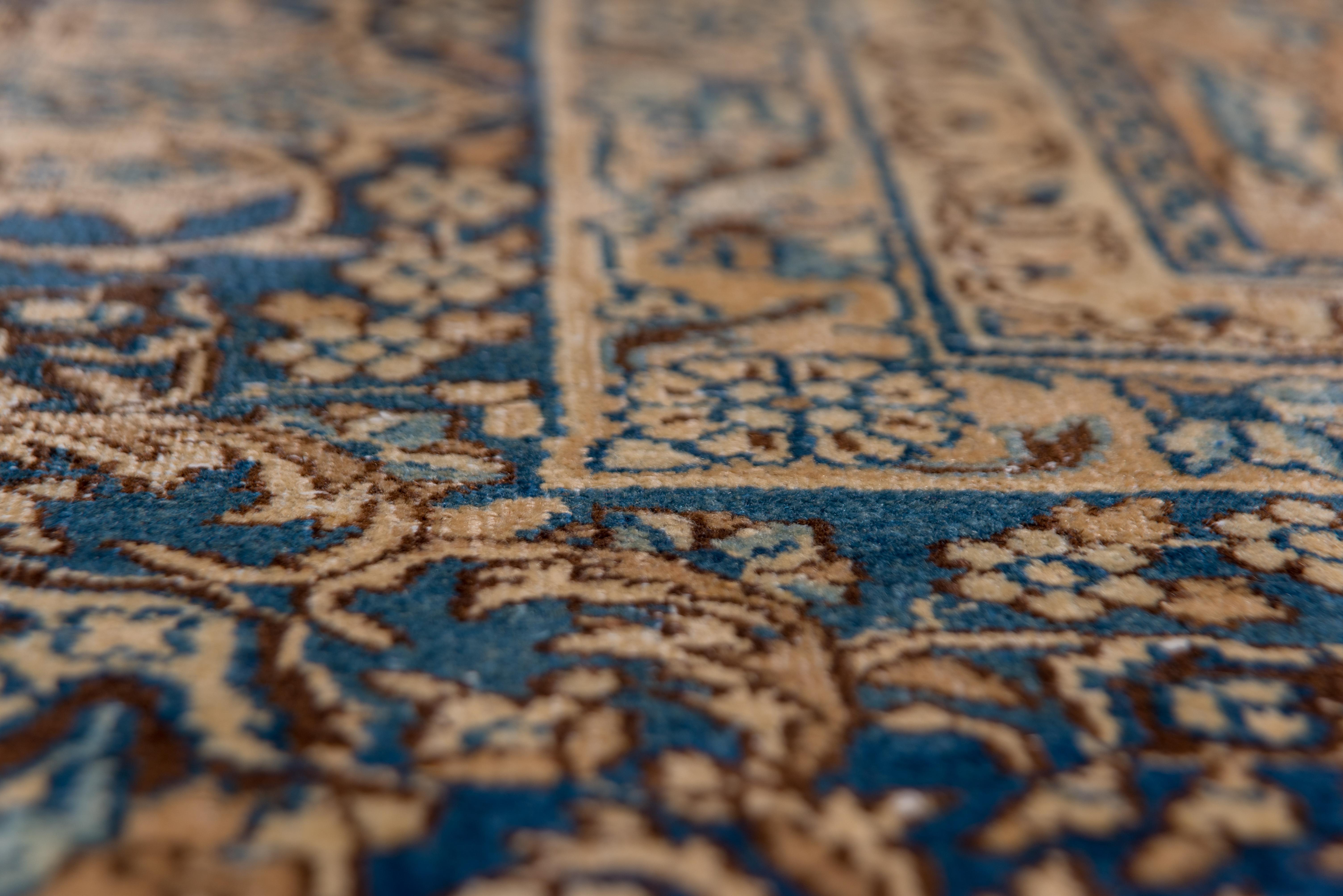 Toutes les teintures naturelles sur ce médaillon classique Kerman du SE de la Perse. Le champ bleu profond présente un médaillon lobé à clapet d'or et de crème avec des arabesques internes fendues plus bleu clair et de larges pendants d'écusson. Des