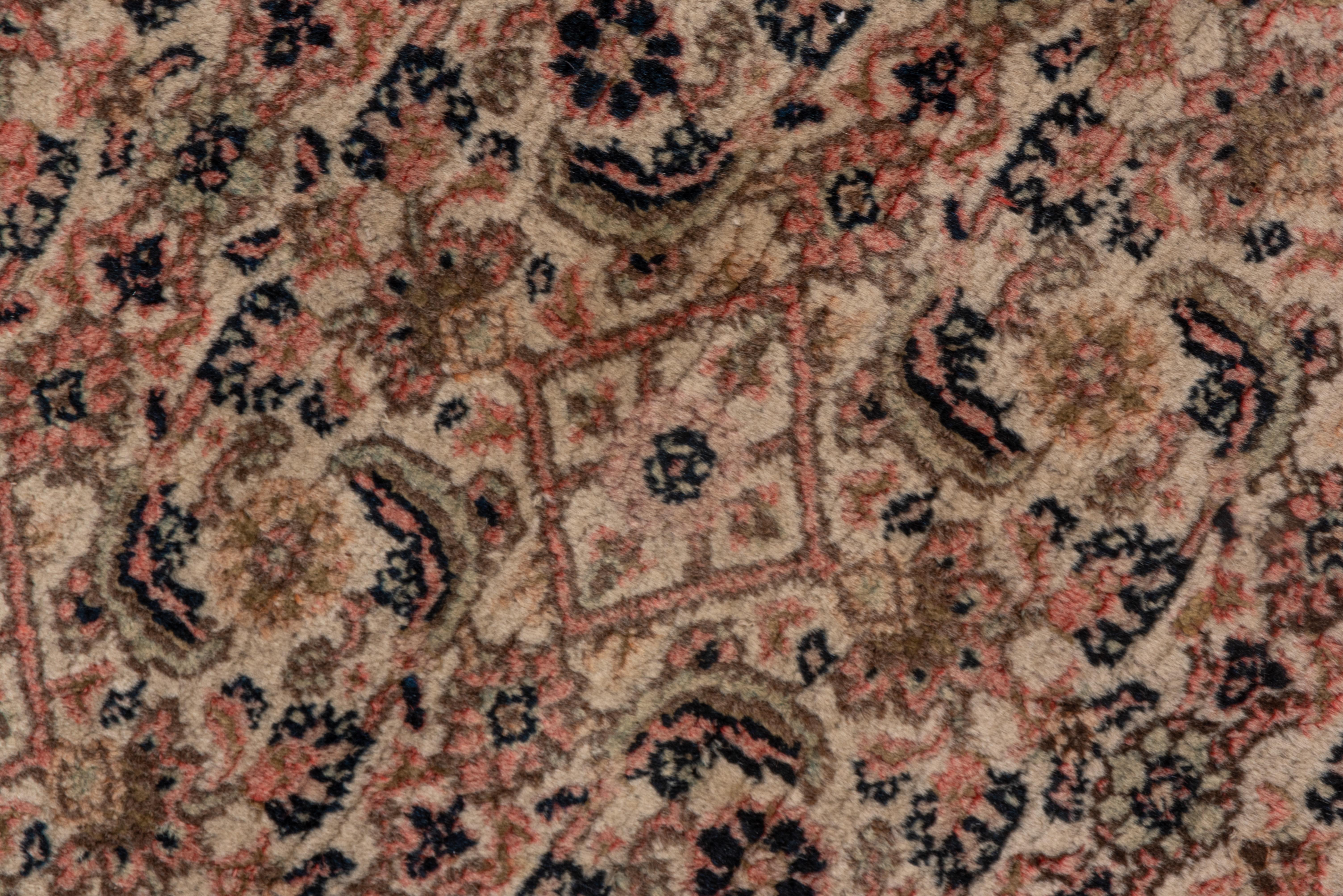 This NE Persian urban antique carpet shows a single scale Herati all-over design in the taupe medallion, in the warm blush field and in the ecru corners. So furniture goes anywhere without ever obstructing the pattern. Lots of borders with two in