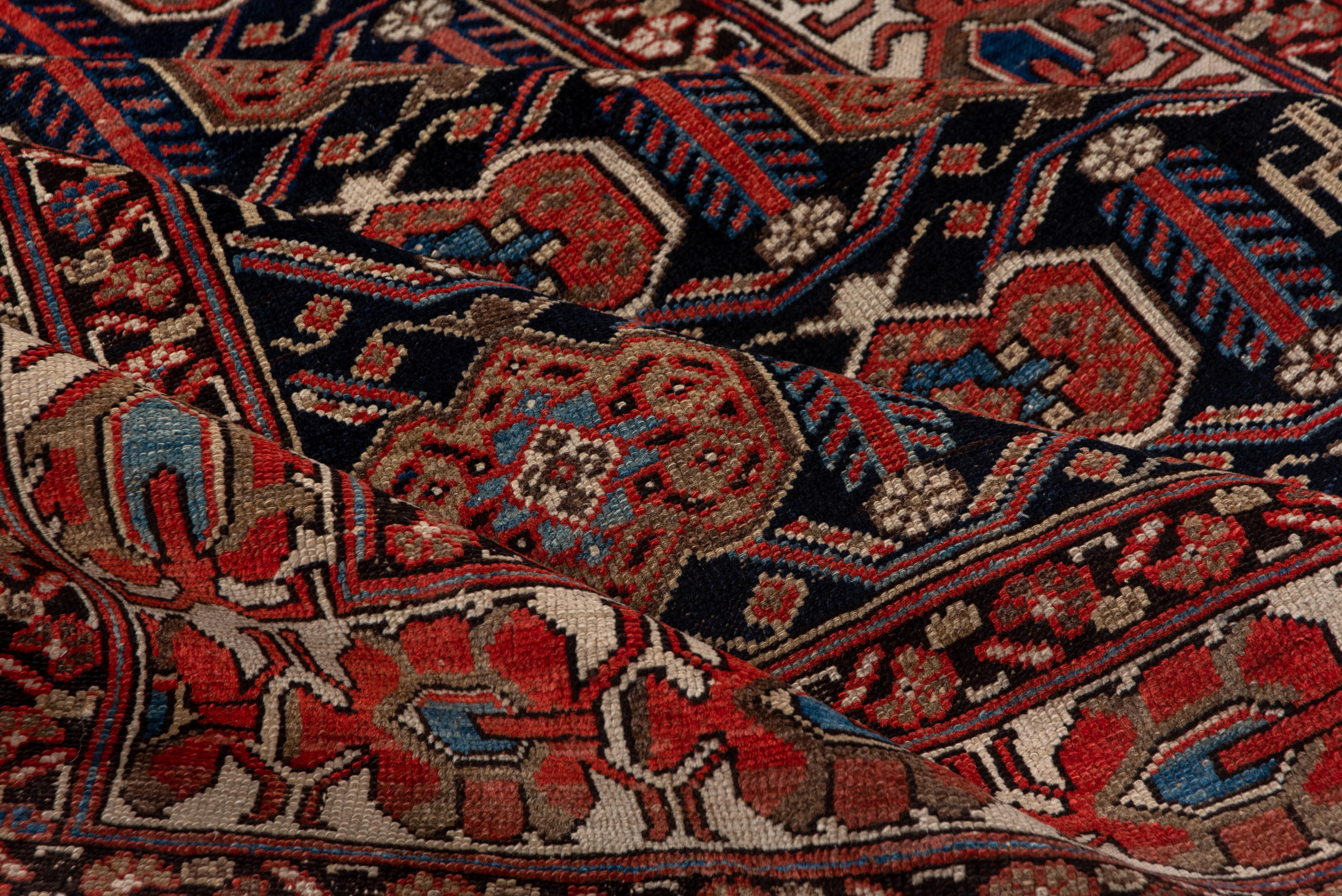 In the Afshar style, this attractive west Persian village scatter shows an offset all-over pattern of turtle palmettes on a black ground. The ivory main border features a progressive array of 