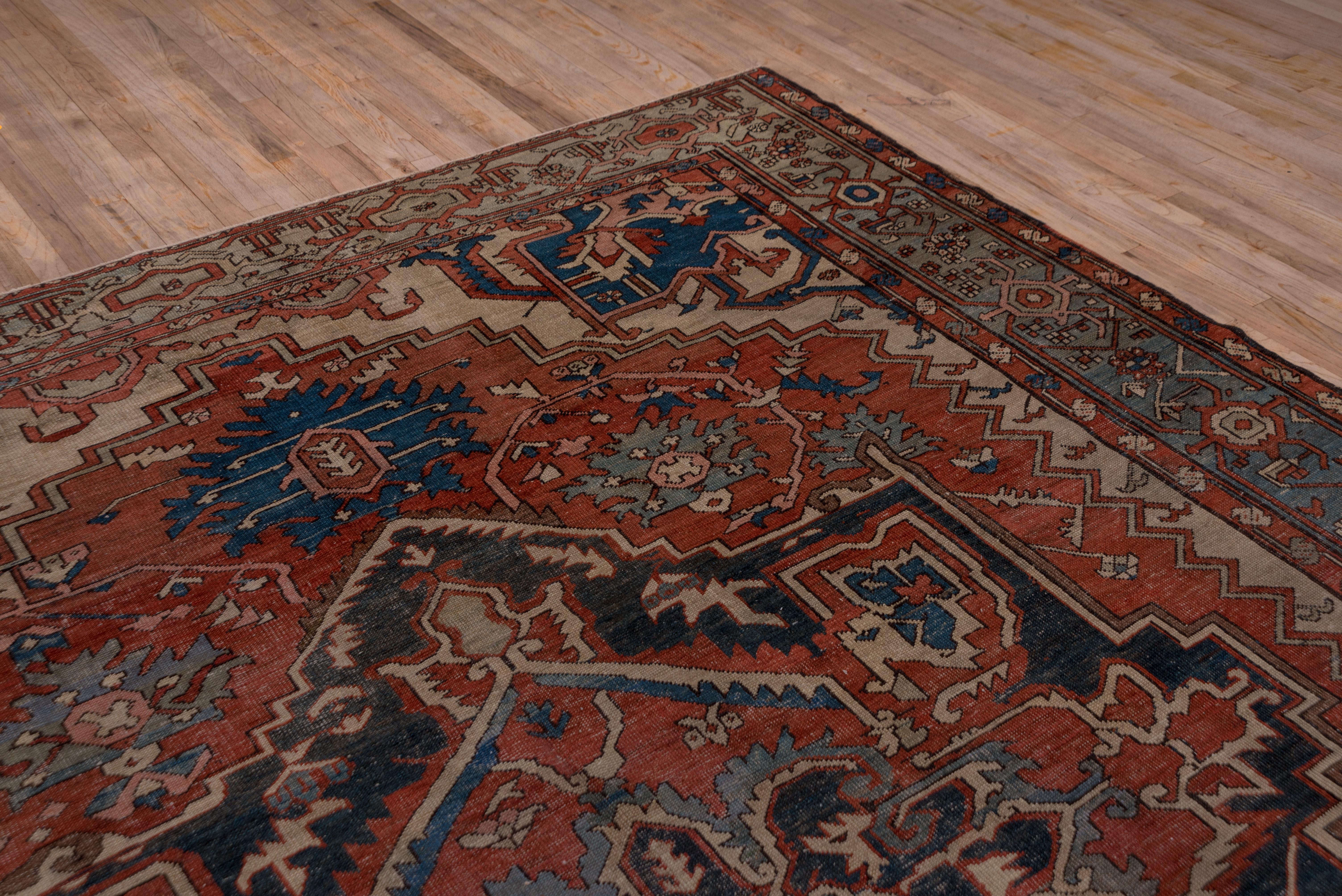 Perfectly naturally dyed and well woven in the Serapi grade, this NW Persian rustic carpet shows an ecru field irregularly, but charmingly, covered by a stepped and notched madder sub field centered by an indigo palmette octogramme. Light corner