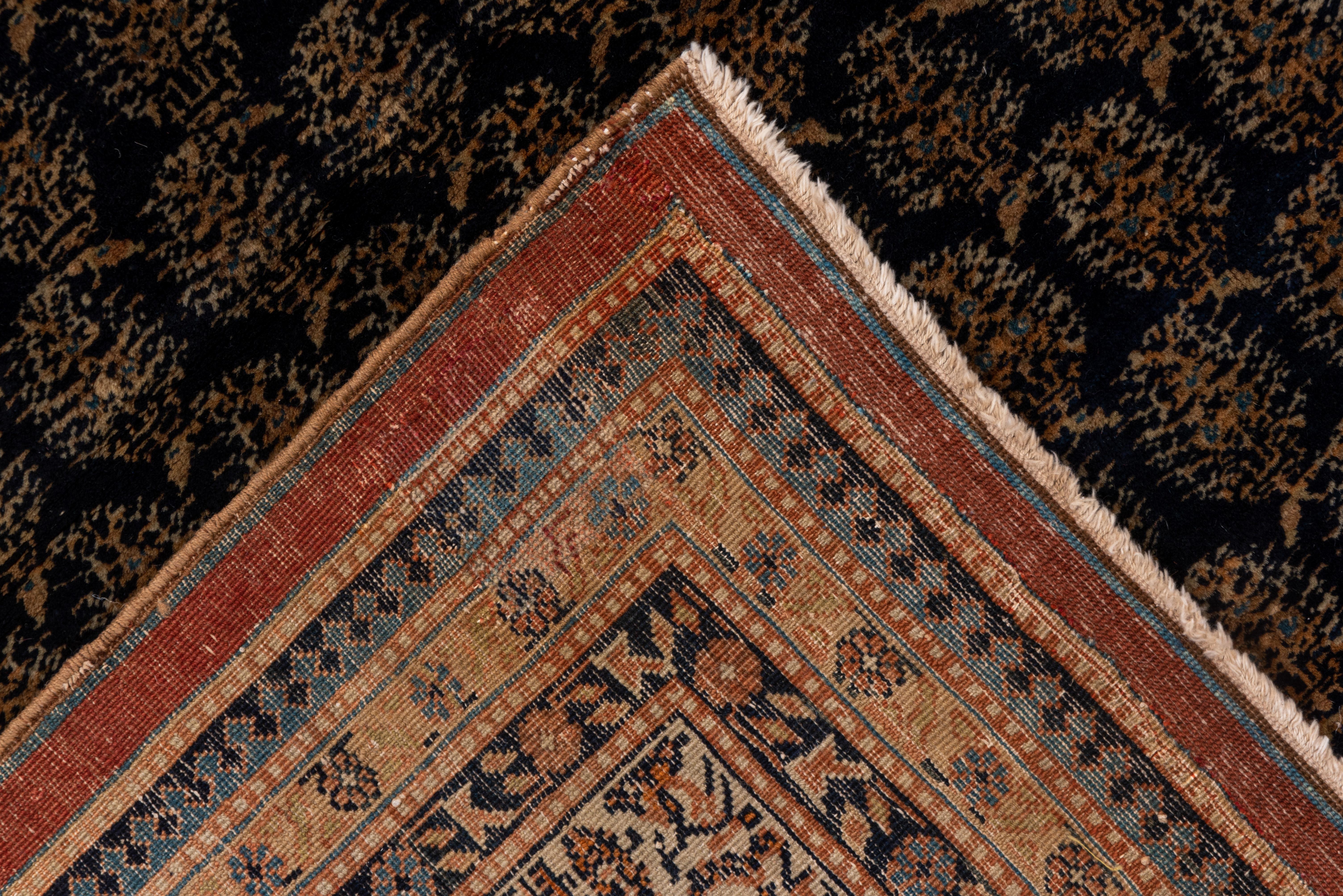 This NW Persian town carpet in a particularly versatile size shows row upon reversing row of fat botehs on a deep navy ground within an ivory meander and boteh border. Saraband style overall.
