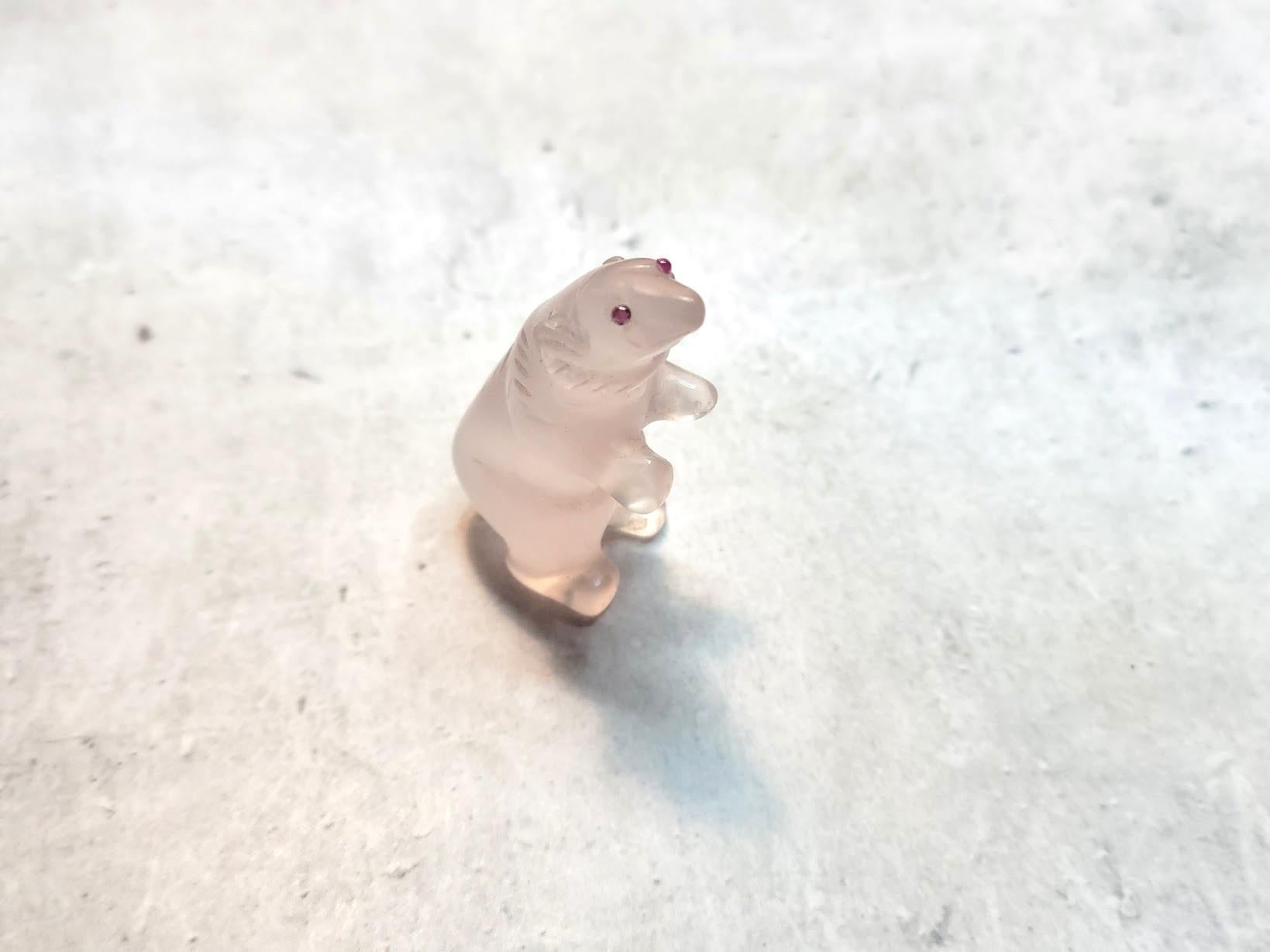 Wir freuen uns, Ihnen ein einzigartiges Kunstwerk aus unserer Sammlung präsentieren zu können: eine Miniaturfigur eines Eisbären, die aus zartem rosa Quarz gefertigt ist. Die Rubinaugen verleihen dieser seltenen Kreation einen Hauch von Eleganz und