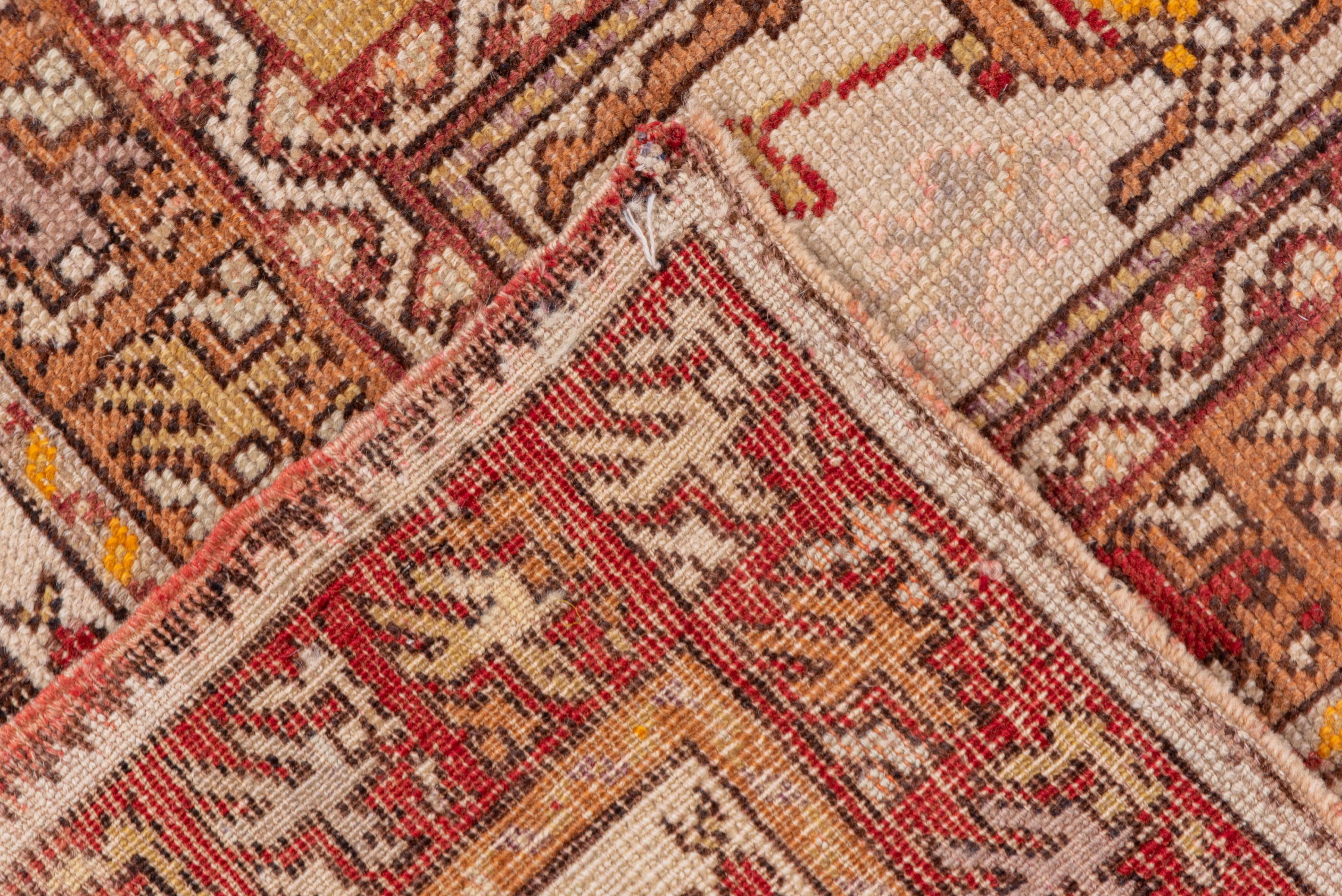 This Anatolian rustic scatter borrows from the Classic Anatolian design vocabulary: striped border, panels at the pale straw field ends. A Bergama-style flower outer border. Botehs on vines flow around the multiply stepped red medallion with a