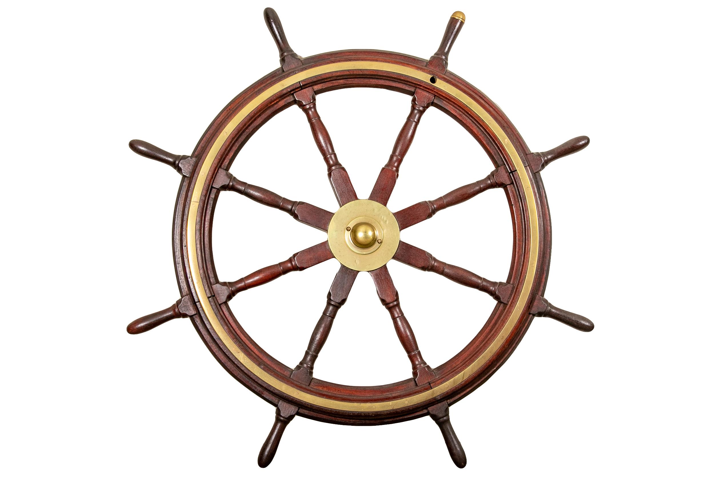 Antique ships wheel. Constructed of Mahogany and brass, with one grip having a brass cap.

Condition: Some slight pitting and tarnish to the brass, wear to the wood on the grips and some on the frame, as expected with use and age.