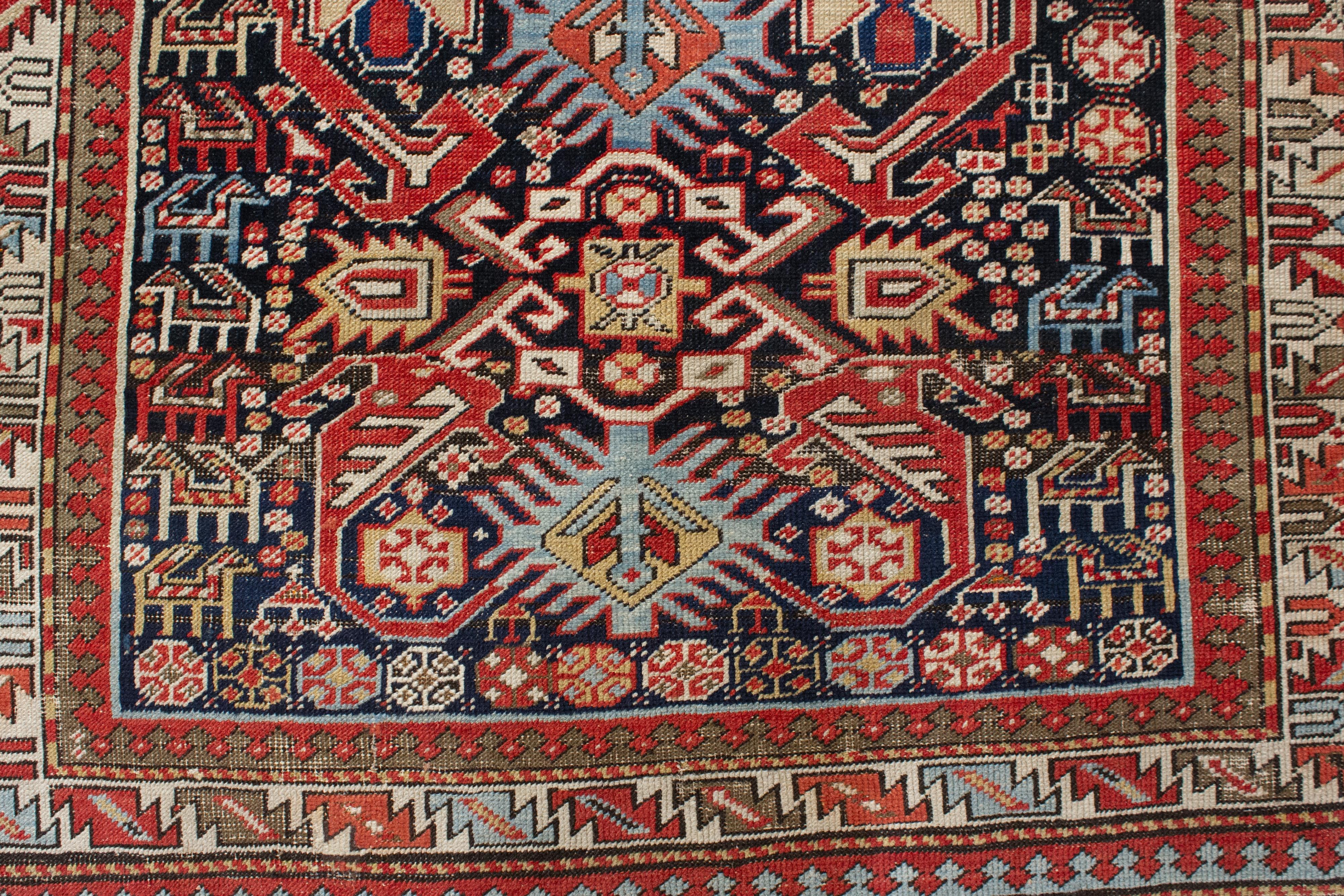 A charming indigo ground antique Shirvan rug, decorated by a central totemic-like element composed of an alternation of white and light blue hooked motif, flanked by a dense array of stylised quadrupeds of different size and type, as well as by