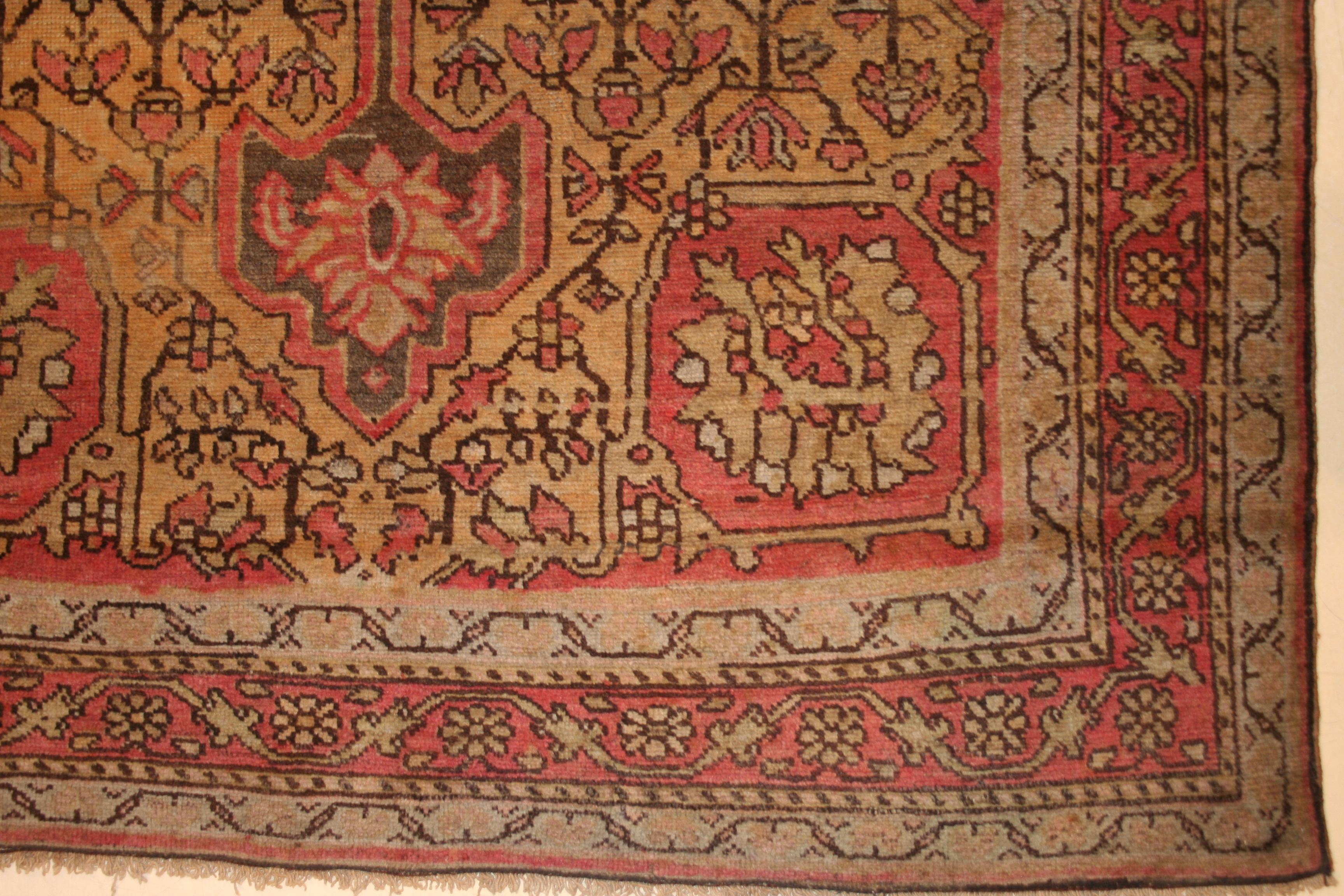 A finely knotted antique scatter sized rug, woven in soft pastel shades, distinguished by a medallion and pendants design in light grey floating on a delicate yellow ground with accents of salmon pink. A classic pattern in a very decorative and easy