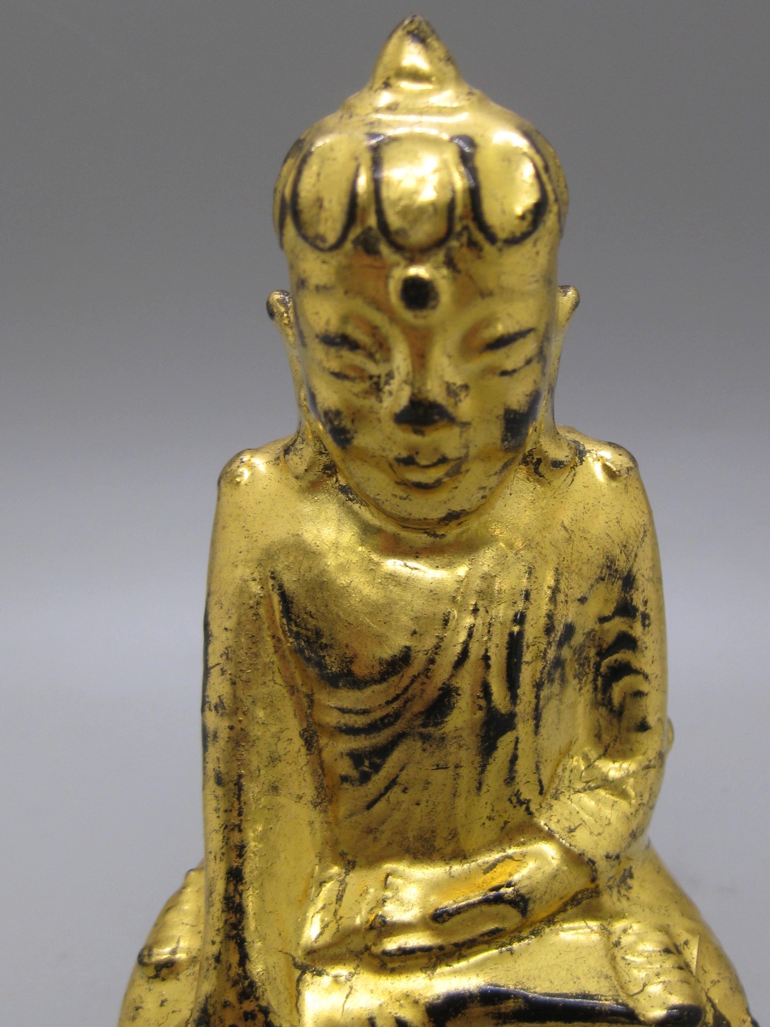Statue en bois sculptée à la main d'un temple antique de Thaïlande et d'Asie du Sud-Est, représentant une divinité bouddhiste. Sculptée en bois, elle est peinte à la main en or 24 carats sur une laque noire. Merveilleuse forme. Les détails sont