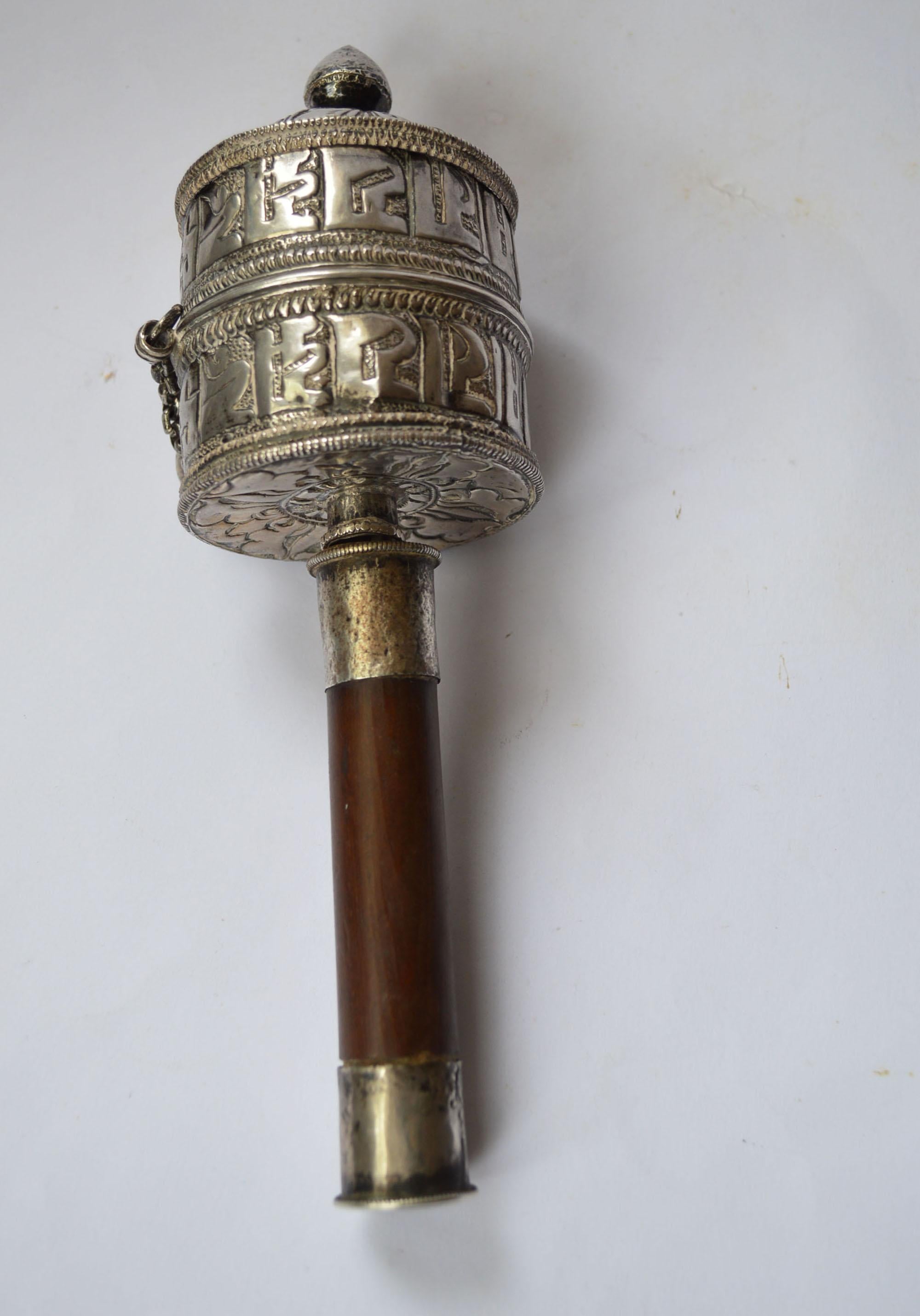 Fine Antique Tibetan Ritual Silver Prayer wheel
Wood handle with hammered and chased design silver in Tibetan script, 
complete with prayer scroll inside the cylinder on parchment paper scroll with Buddhist mantras.
Very finely made in high grade