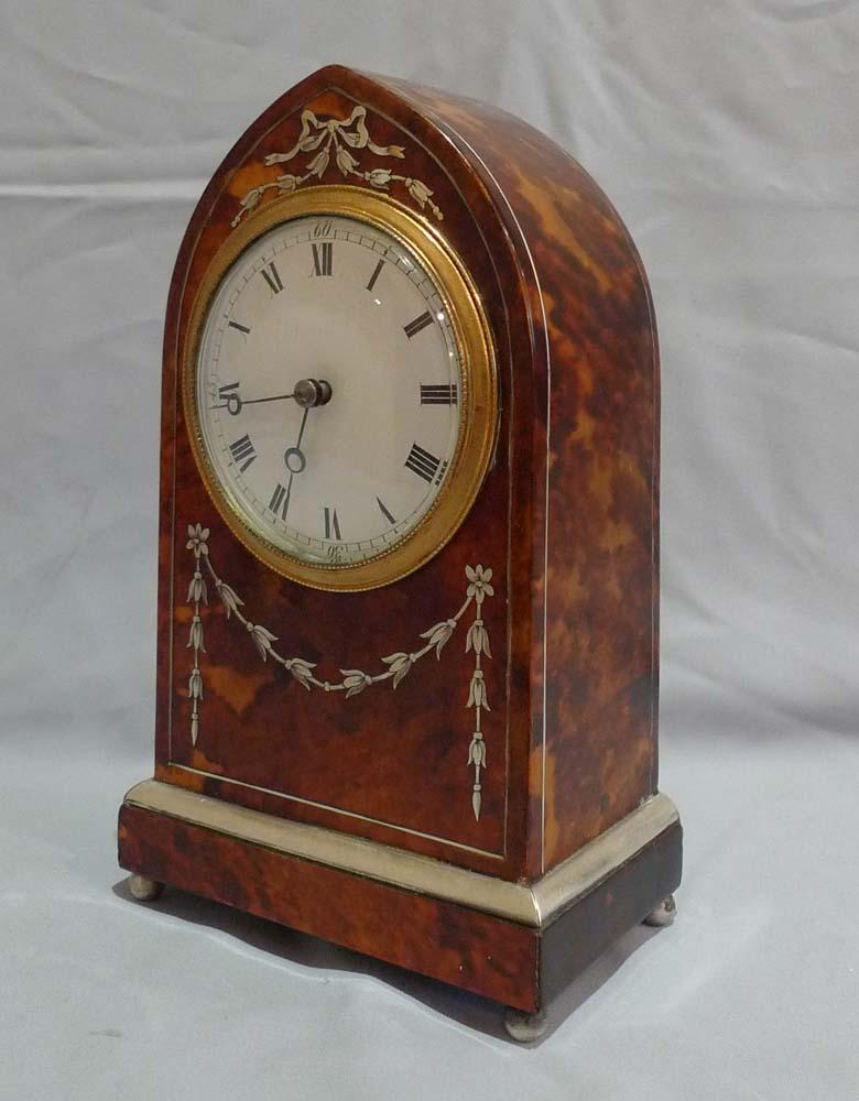 Tortoiseshell and silver inlaid antique mantel clock. English and Edwardian this is a very pretty and unusual case. The tortoiseshell veneers have been laid over a gold ground on the carcass which results in a very deep lustrous gold colour to the