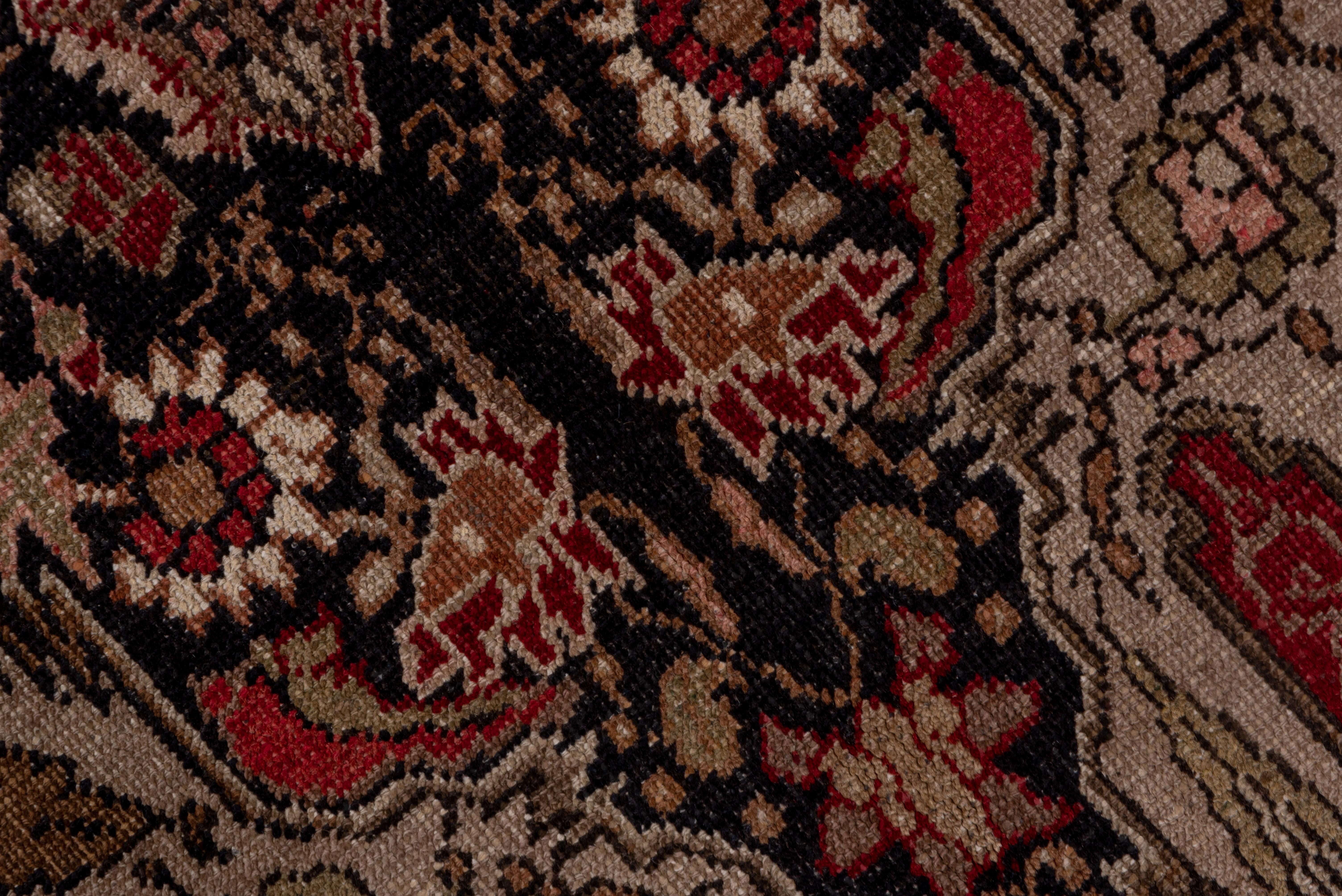 Definitely in the Persian Kashan style, this well-woven Anatolian rug shows a pair of columns with broad sand extensions at each end, with a close scatter of leaves and flowers, on the dark brown ground. Red border of cypresses alternating with