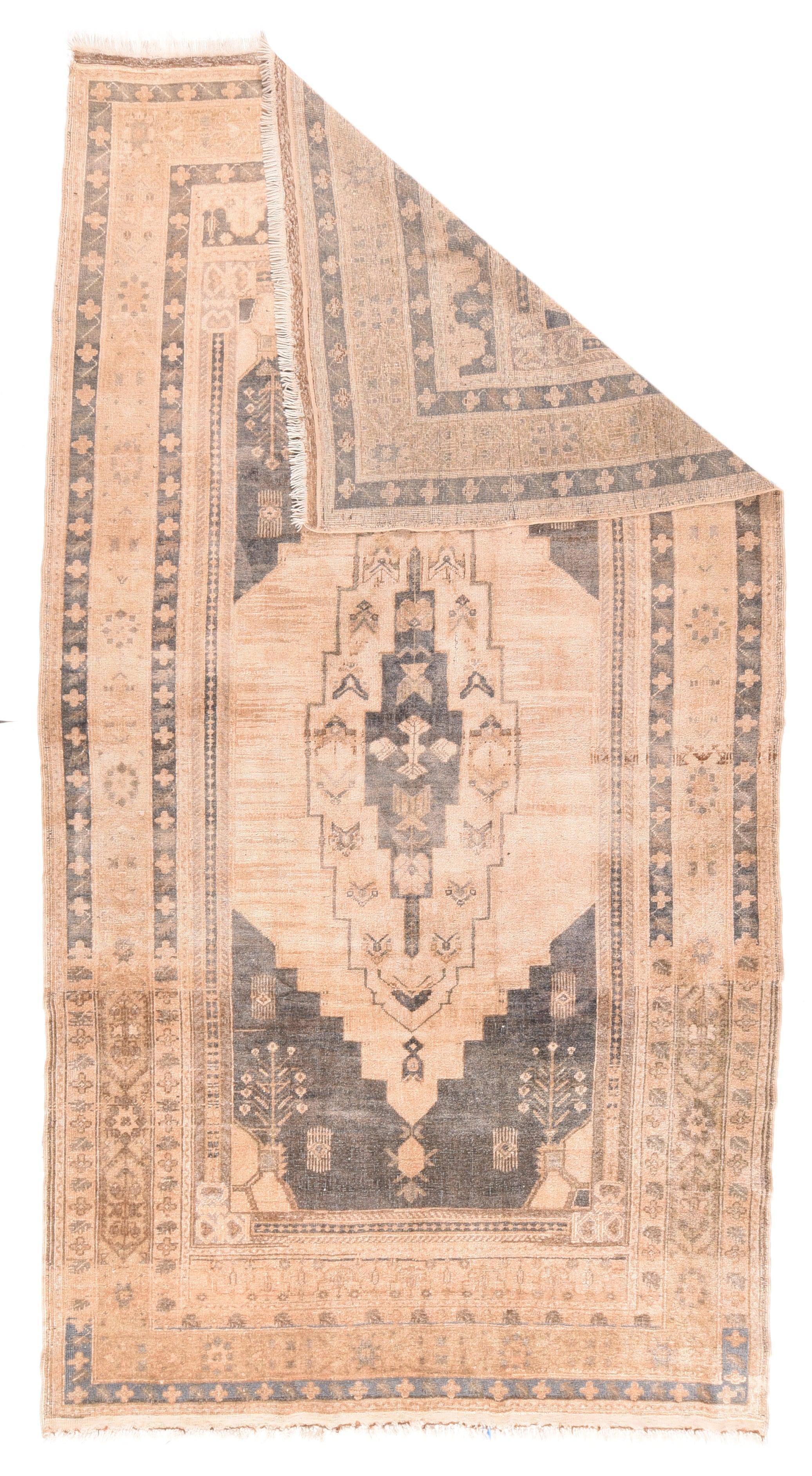 Feiner antiker türkischer Oushak-Wollteppich 5'9'' x 10'7''. Das lila-braune Feld zeigt ein gestuftes sandfarbenes Unterfeld, in dessen Mitte sich ein hohes, breit gestuftes ecrufarbenes Kartuschenmedaillon befindet. Aus den winzigen Ecken wachsen