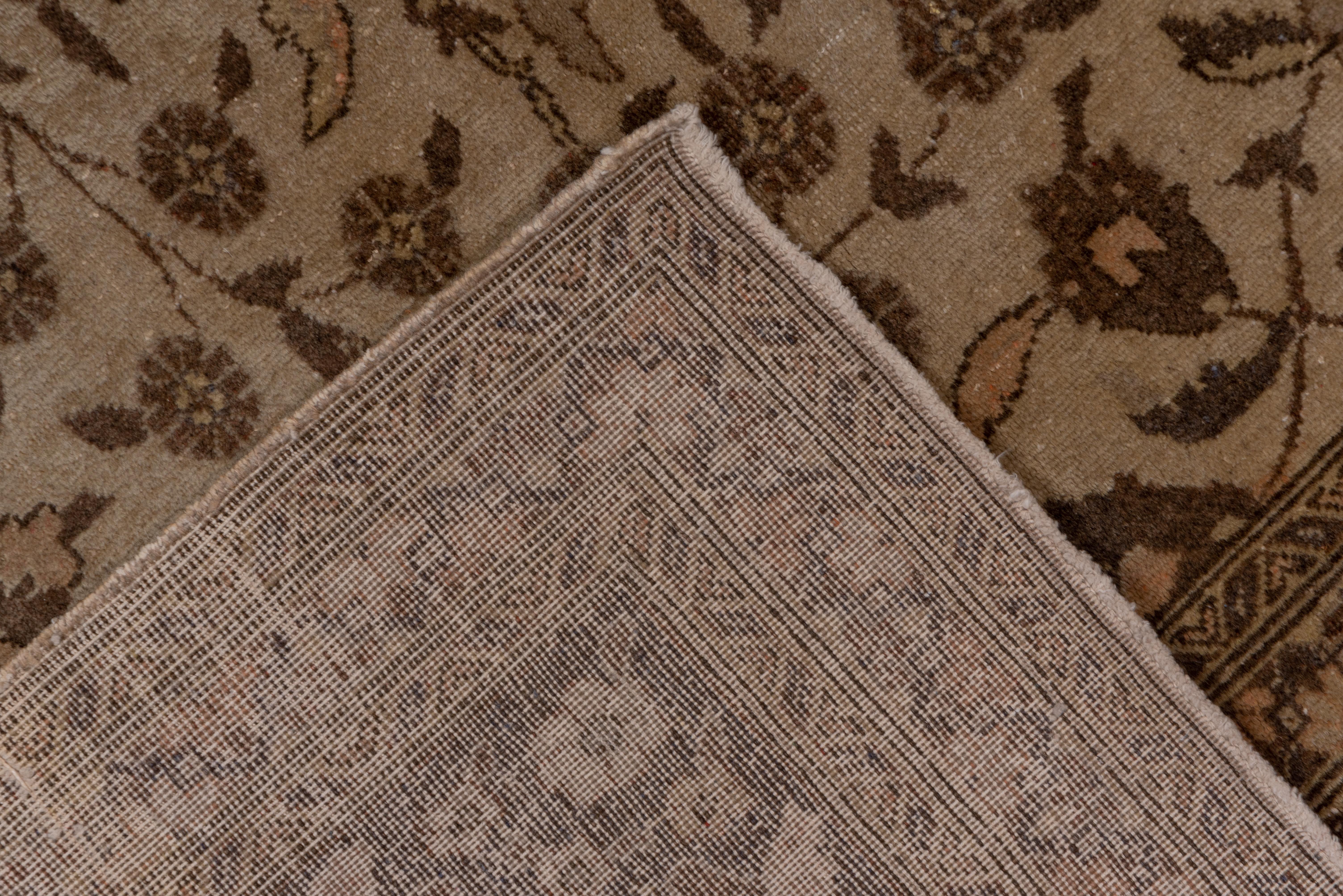 Eastern Turkish Sivas carpets are very much in the urban Tabriz style, as evidenced here by the ivory field with a small leaf, palmette and rosette design organized around an implicit central axis, with a brown escutcheon palmette and hyacinth spray