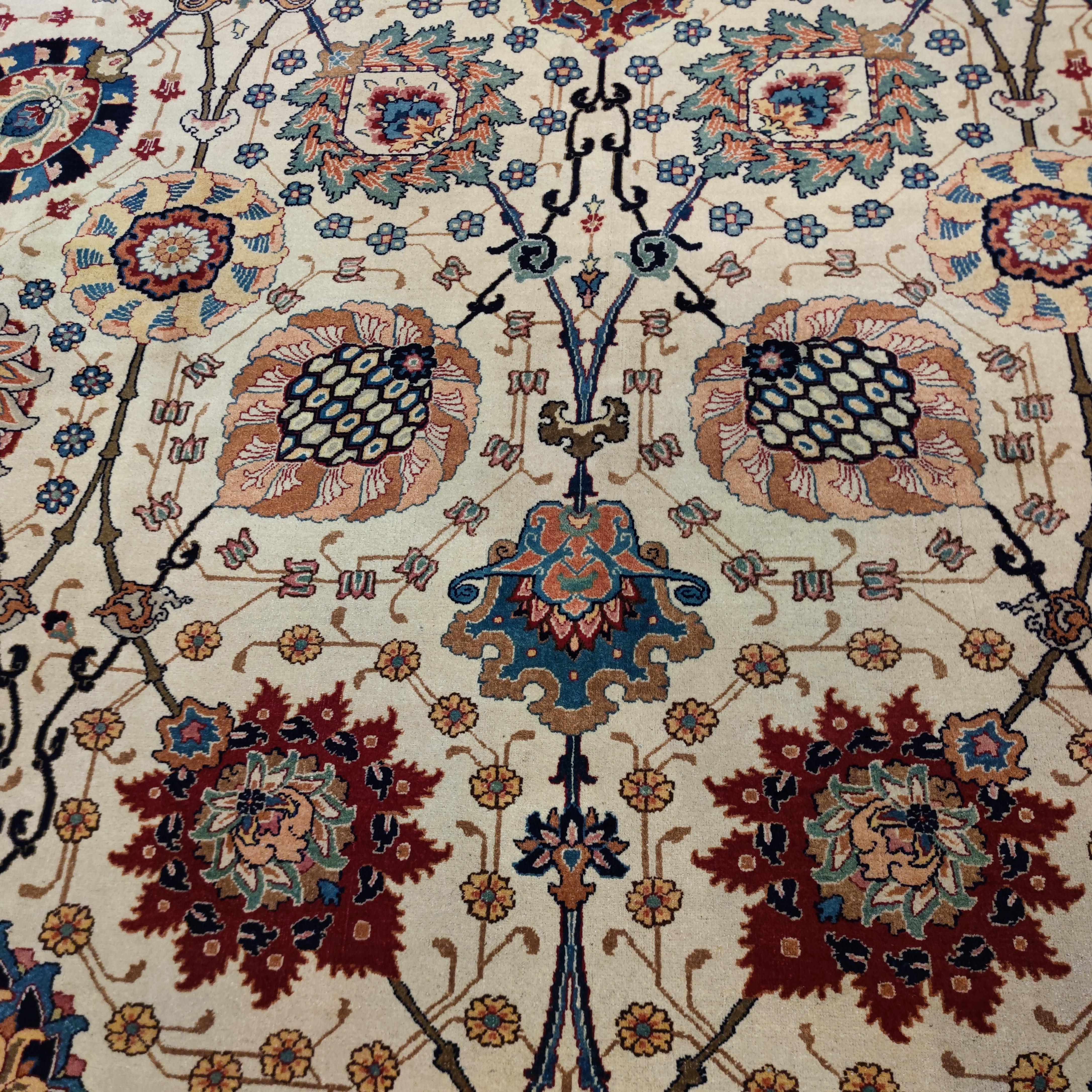 This stunning antique Tabriz carpet, woven in the prestigious Benlian workshop, is distinguished by an ivory background layered with a large-scale all-over pattern of multicoloured scrolling palmettes. This design derives from 17th-century Safavid
