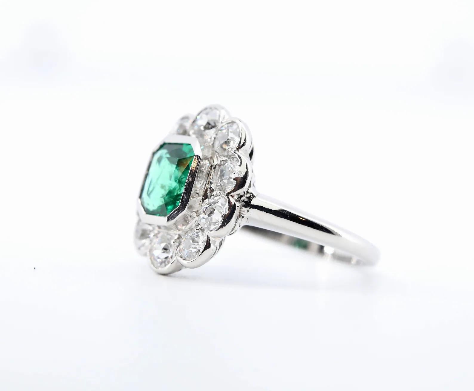 An Art Deco period emerald, and diamond ring set in platinum.

Centered by a bezel set rich vivid forest green 1.10 carat emerald. The emerald is of very fine clarity, having only the most minor oil treatment per the accompanying GIA