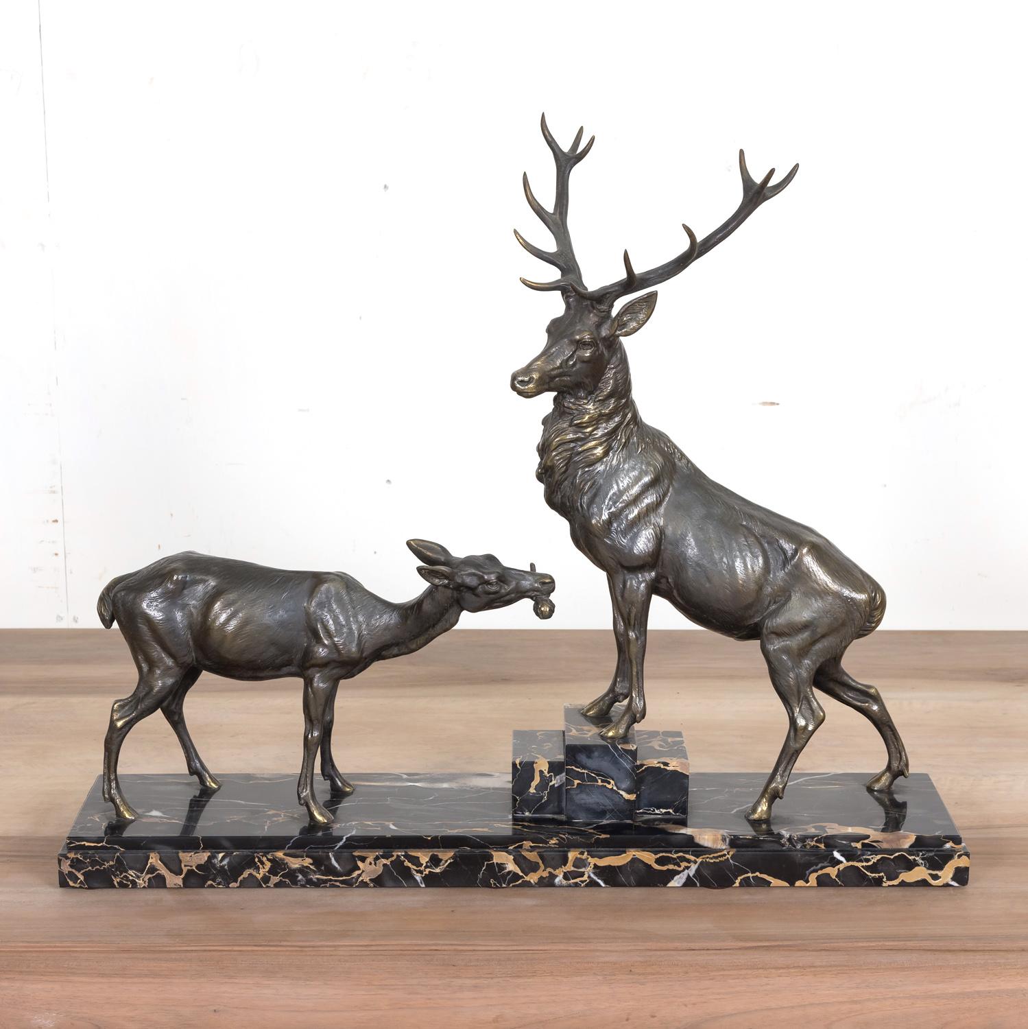 A fine Art Deco spelter animalier sculpture, naturalistically modeled and posed, of a twelve point stag and doe by French artist Louis Albert Carvin. The stag with his front legs raised on marble blocks and the whole mounted on a stunning