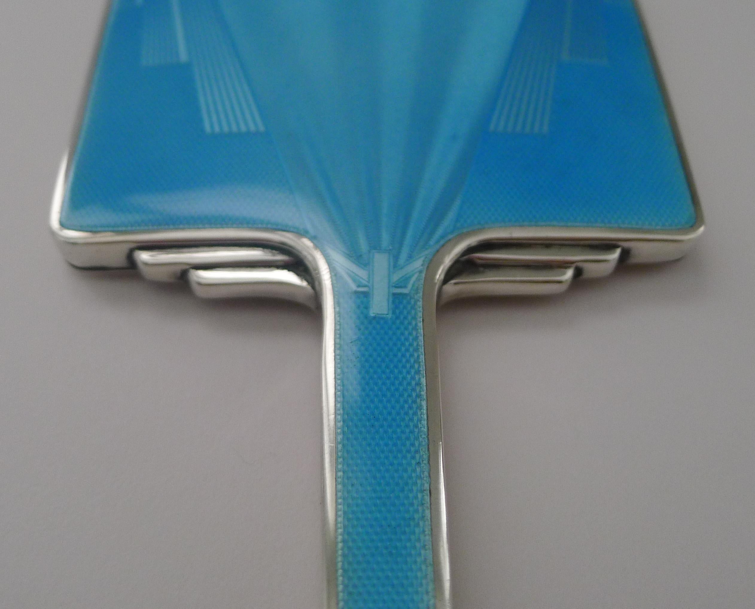 Ein hervorragender Art-Deco-Spiegel aus englischem Sterlingsilber, gesegnet mit einer wunderschönen blauen Guilloche-Emaillierung in unbeschädigtem Zustand.

Der Spiegel selbst ist ebenfalls in ausgezeichnetem Zustand.

Das Silber ist vollständig