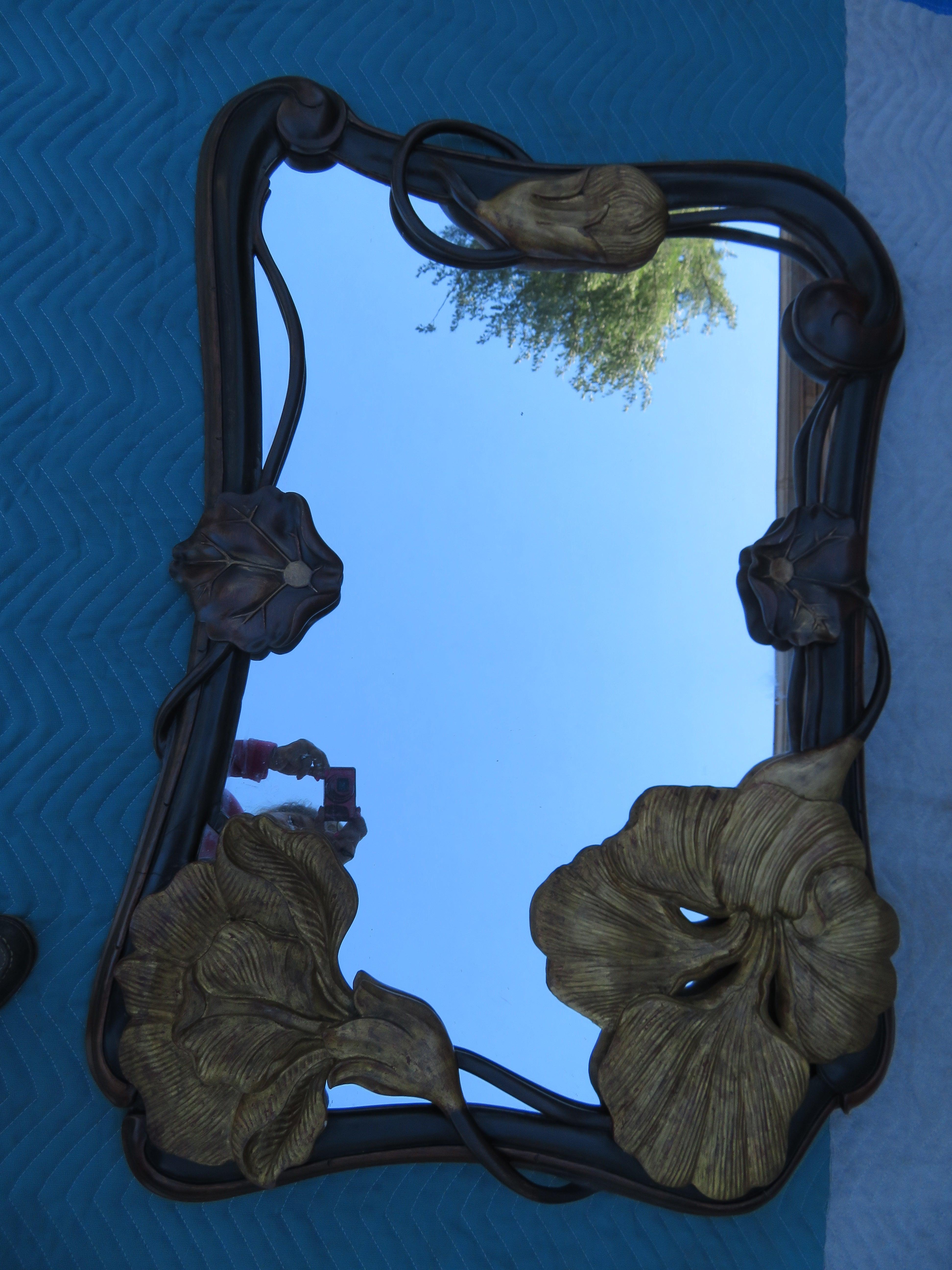 Grand scale beautifully carved full bloom flower and bud Art Nouveau mirror.  We love the dark Rich Mahogany and Ebony with gilt accents designed in the style of Louis Majorelle, circa early 19th century. This piece measures 45