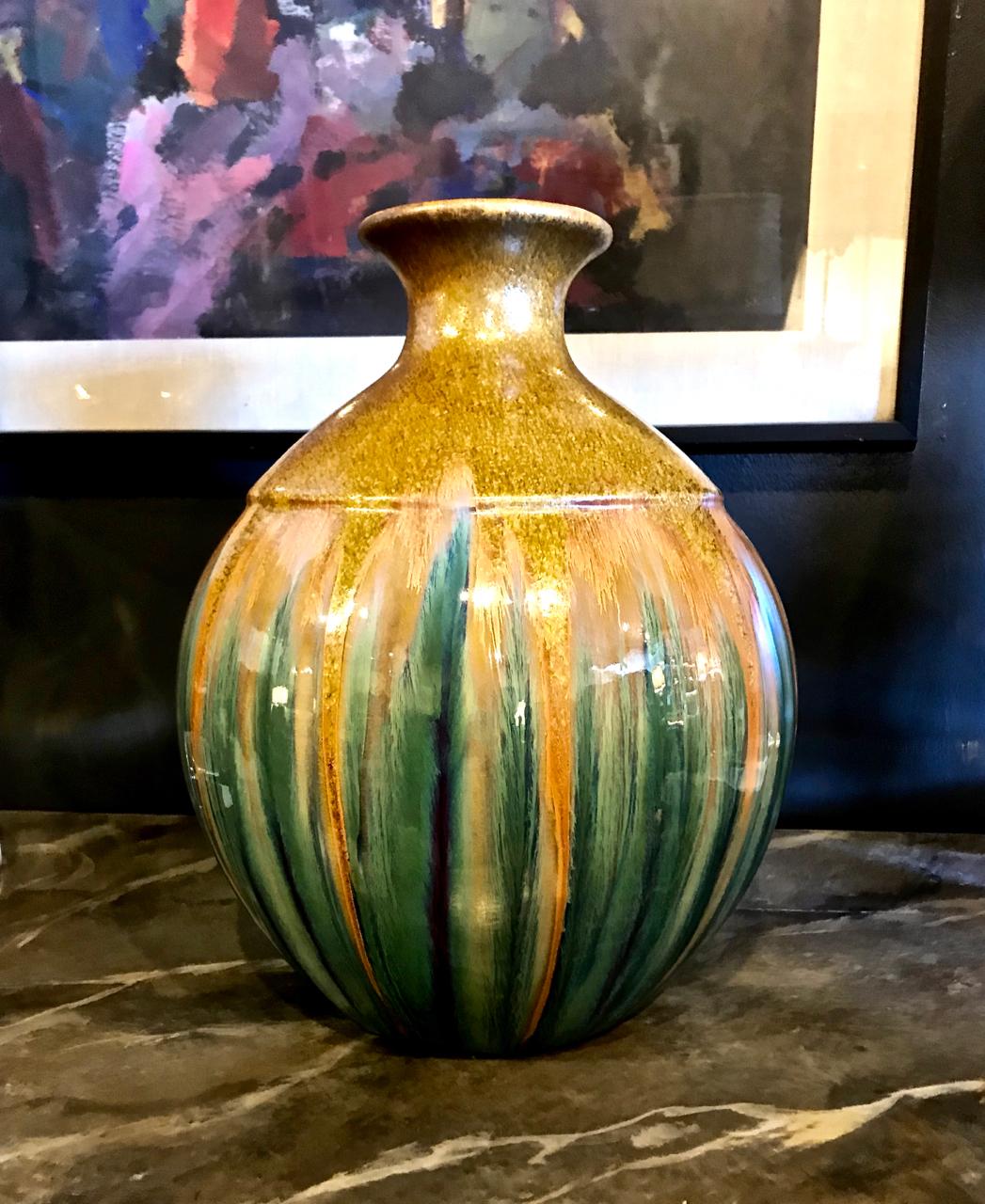 Il s'agit d'un vase unique du 20e siècle, magnifiquement irisé et émaillé. Le vase a été poté à la main dans une forme traditionnelle ; la surface finement émaillée comprend des paillettes d'or 24 carats sur le tiers supérieur du vase. Il y a une