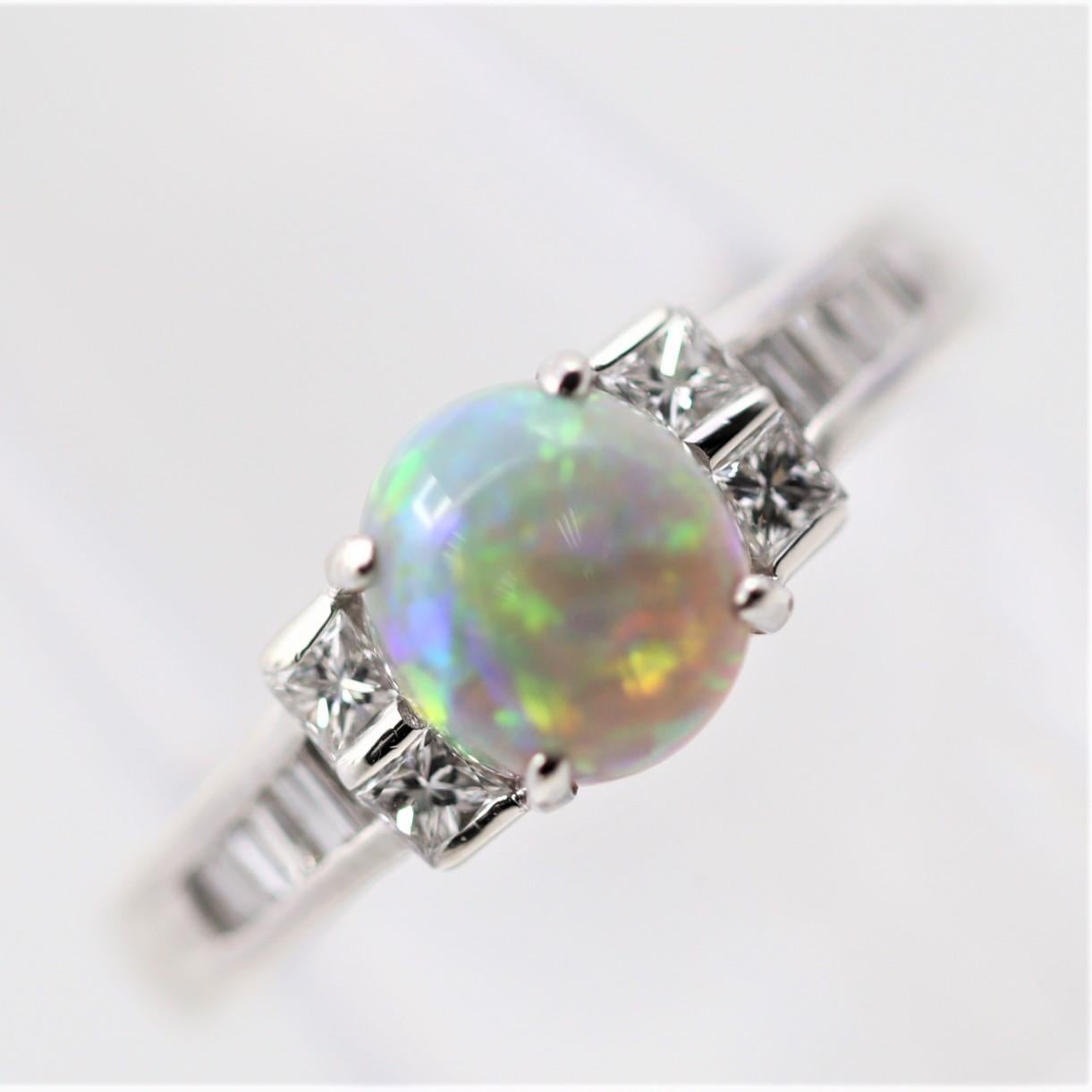 An exceptionally fine natural Australian opal takes center stage of this platinum made ring. It weighs 1.44 carats and has excellent play-of-color as an array of colors, from red and blue to orange and green, shine brightly across the entirety of